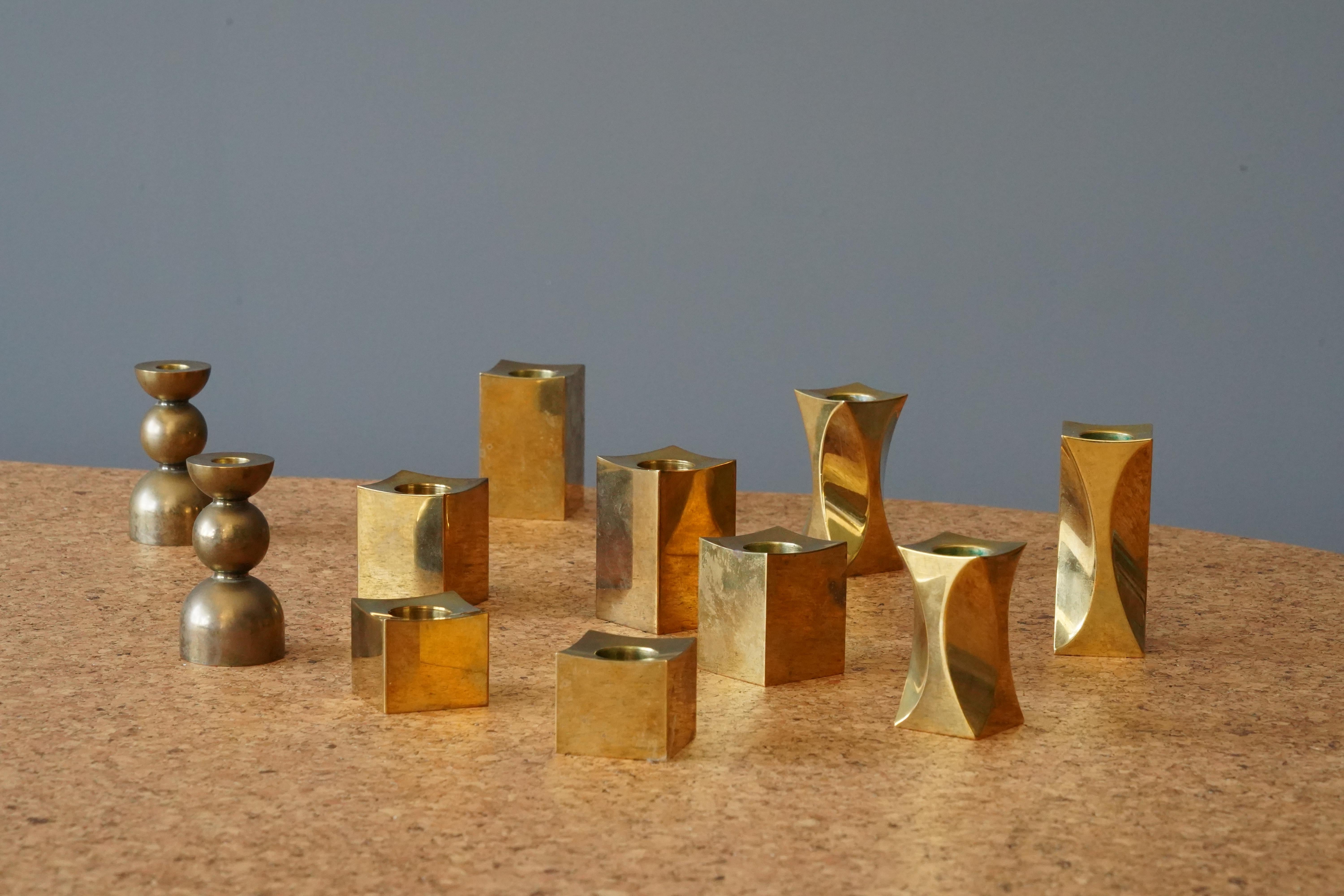 A set of 11 candle holders. Design and production by Metallslöjden Gusums Bruk, Sweden. In heavy alloy brass.