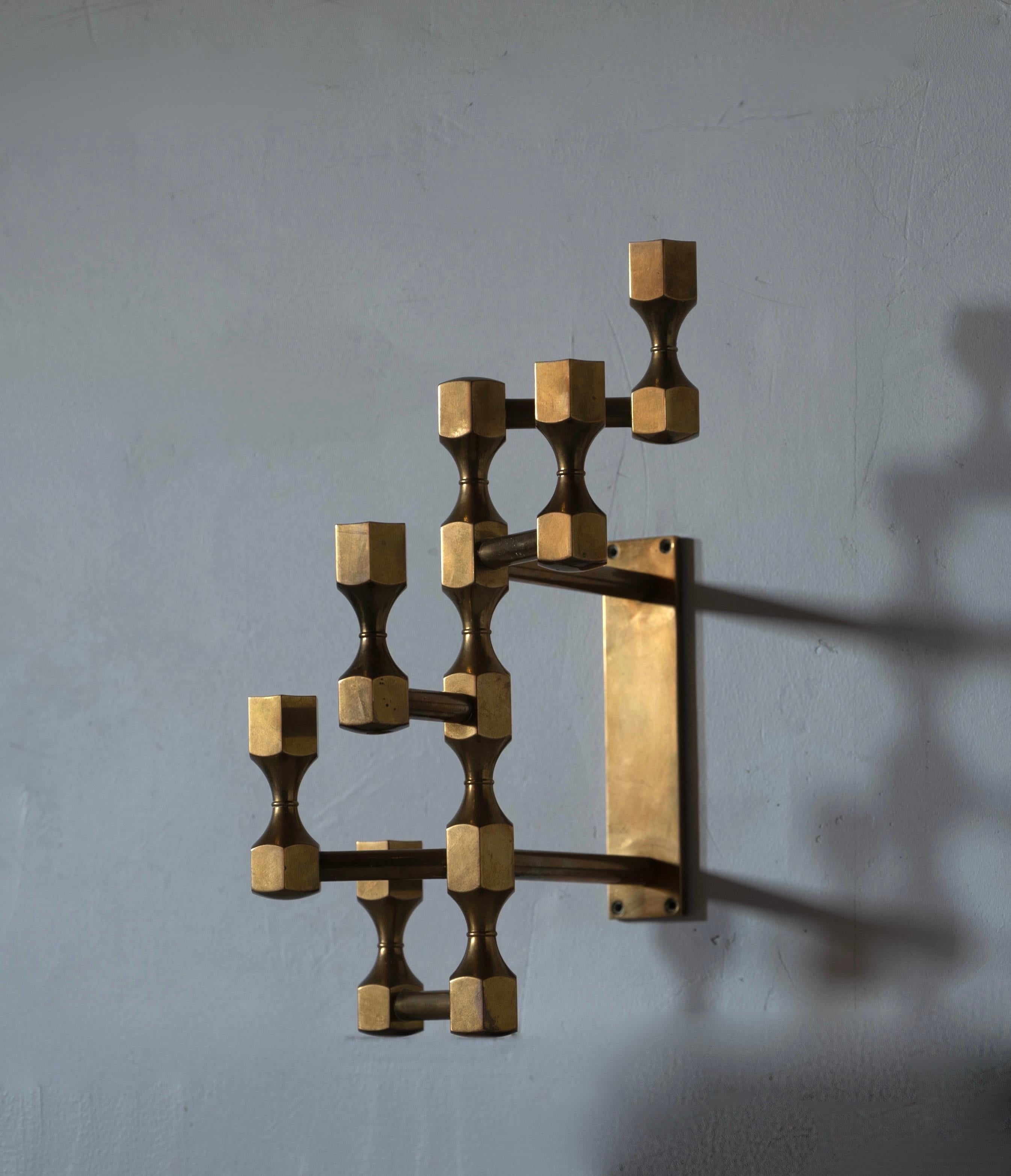A wall mounted candelabra. Design and production by Metallslöjden Gusums Bruk, Sweden. In heavy alloy brass.