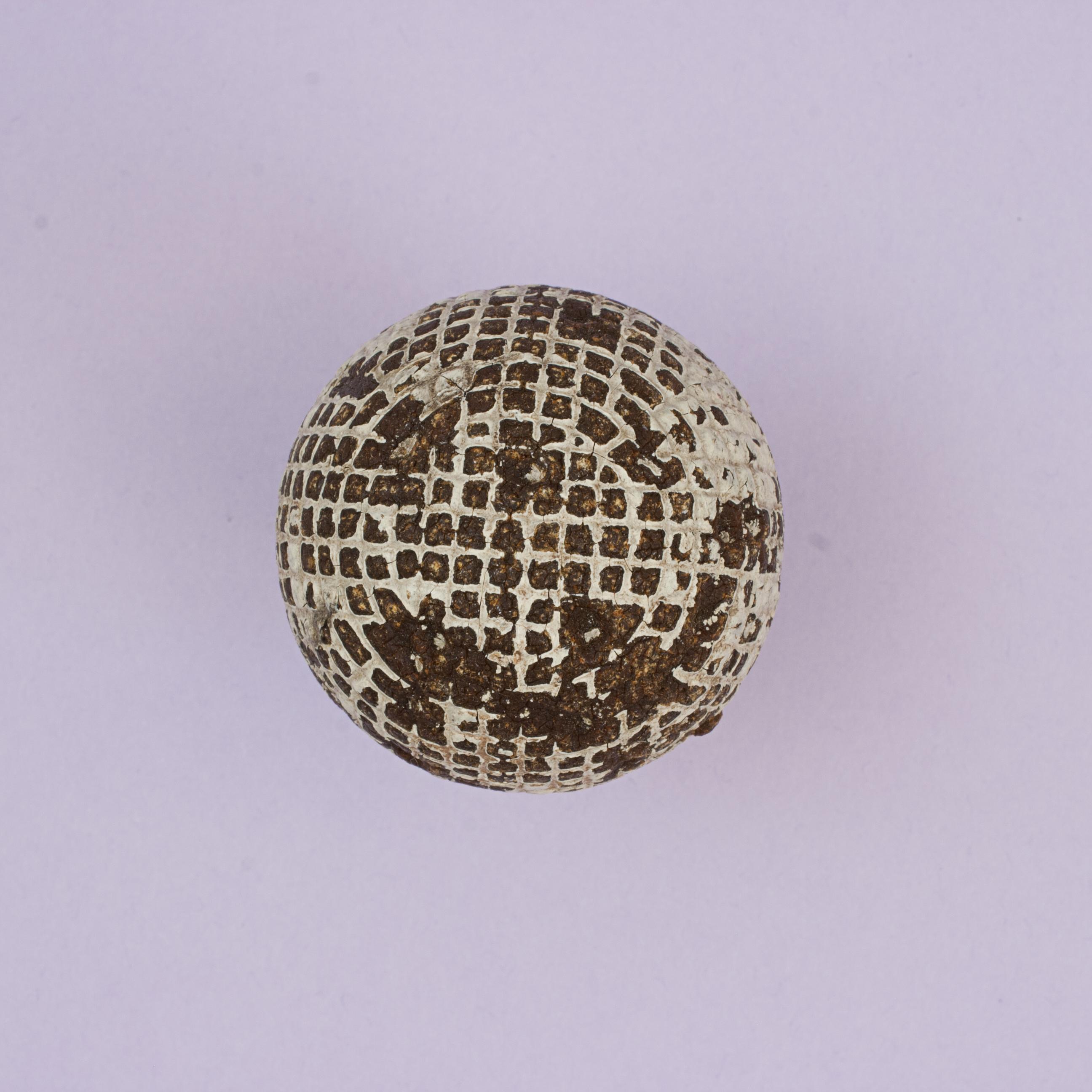 Solid Mesh Gutty Golfball.
Ein solider geformter Guttapercha-Golfball mit quadratischem Netzmuster in gut gebrauchtem Zustand. Der Gutty-Ball aus den 1890er Jahren hat noch einen Teil der ursprünglichen Oberflächenbehandlung.
Die Kugel hat einen
