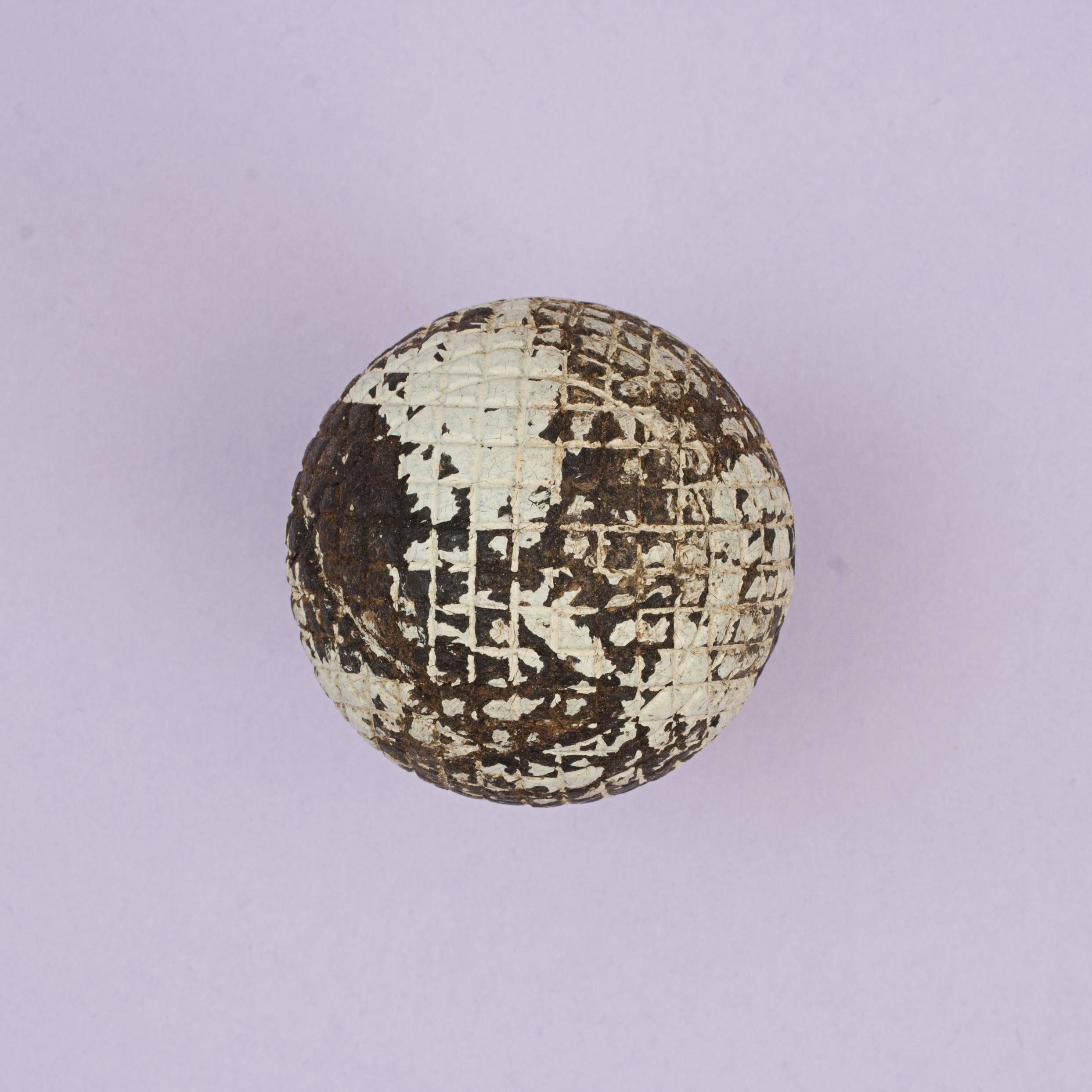 Pelota de golf de malla maciza.
Pelota de golf de gutapercha con diseño de malla cuadrada, moldeada y maciza, en buen estado de uso. La bola Gutty de 1890 aún conserva parte del acabado original de su superficie.
La bola mide aproximadamente 4.2 cm