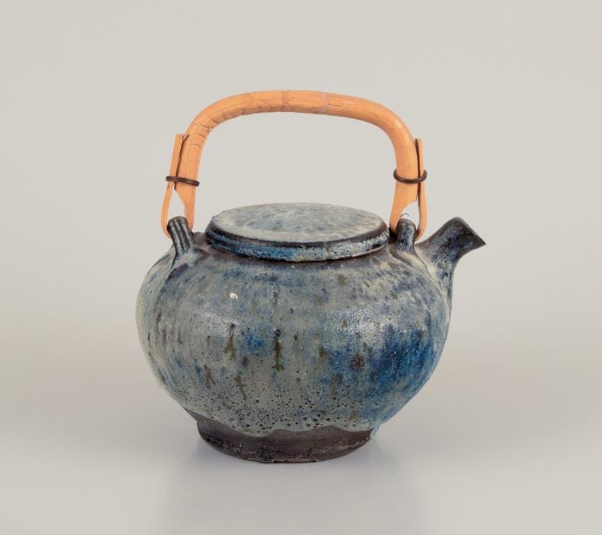 Gutte Eriksen, Danimarca.
Teiera in ceramica unica, tecnica raku, smalto lavico fluente nei toni del grigio-blu.
Manico in bambù.
Circa 1960.
Condizioni perfette.
Dimensioni: L 17,0 cm x H 17,0 cm con maniglia.

Gutte Eriksen è stata un'artista