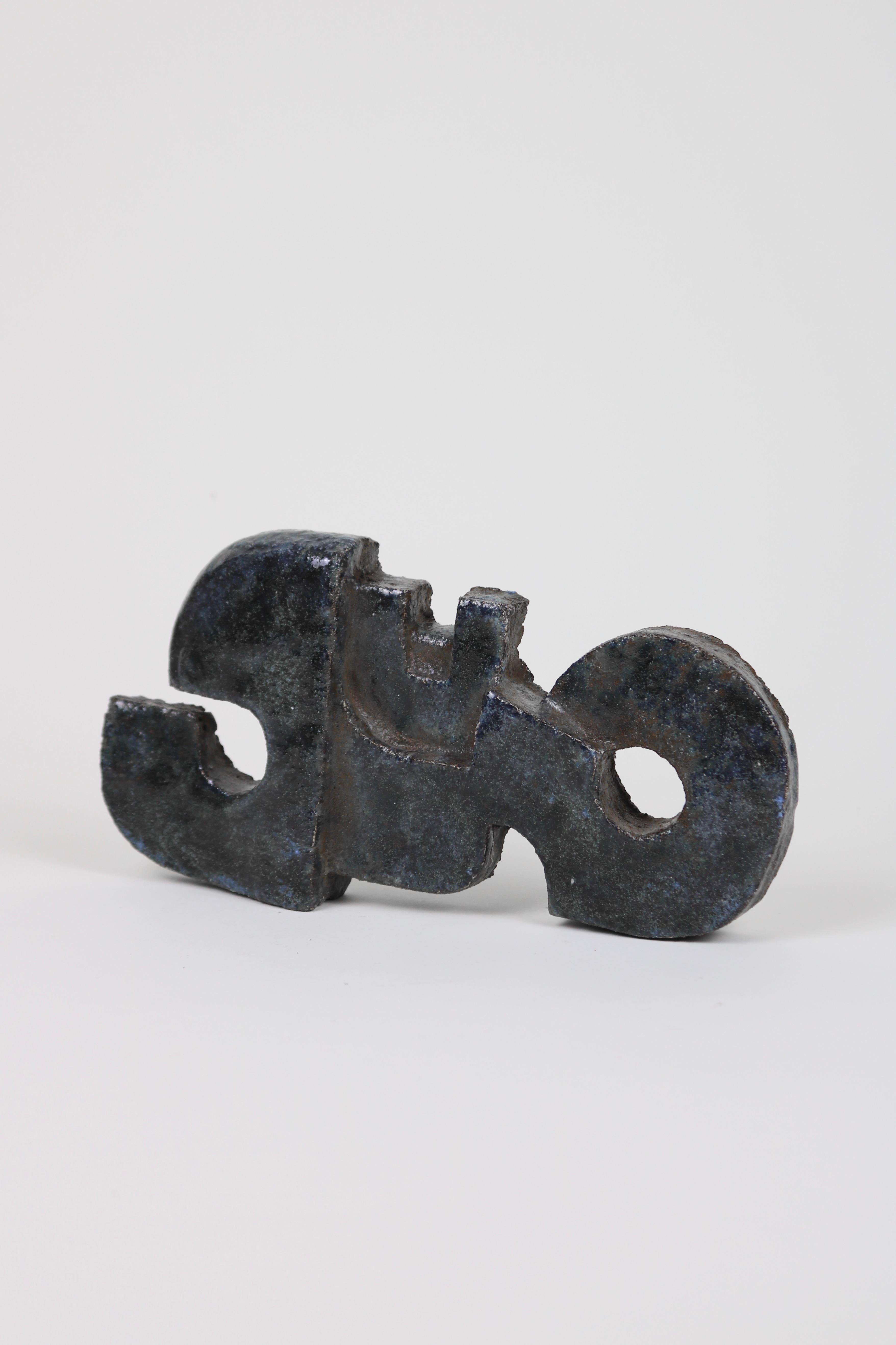 An abstract form made from clay with a blue-hued glaze. Can be laid flat or wall-hung. 

Guus Zuiderwijk is a Dutch sculptor and artist. This piece is thought to be an output from his time at the innovative Experimental Department of De Porceleyne