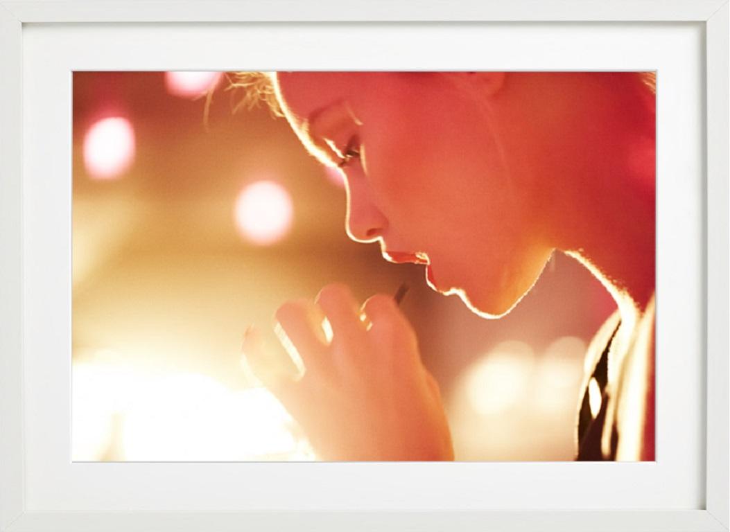 Untitled Face of blonde woman in sunlight drinking from straw - Photograph by Guy Aroch