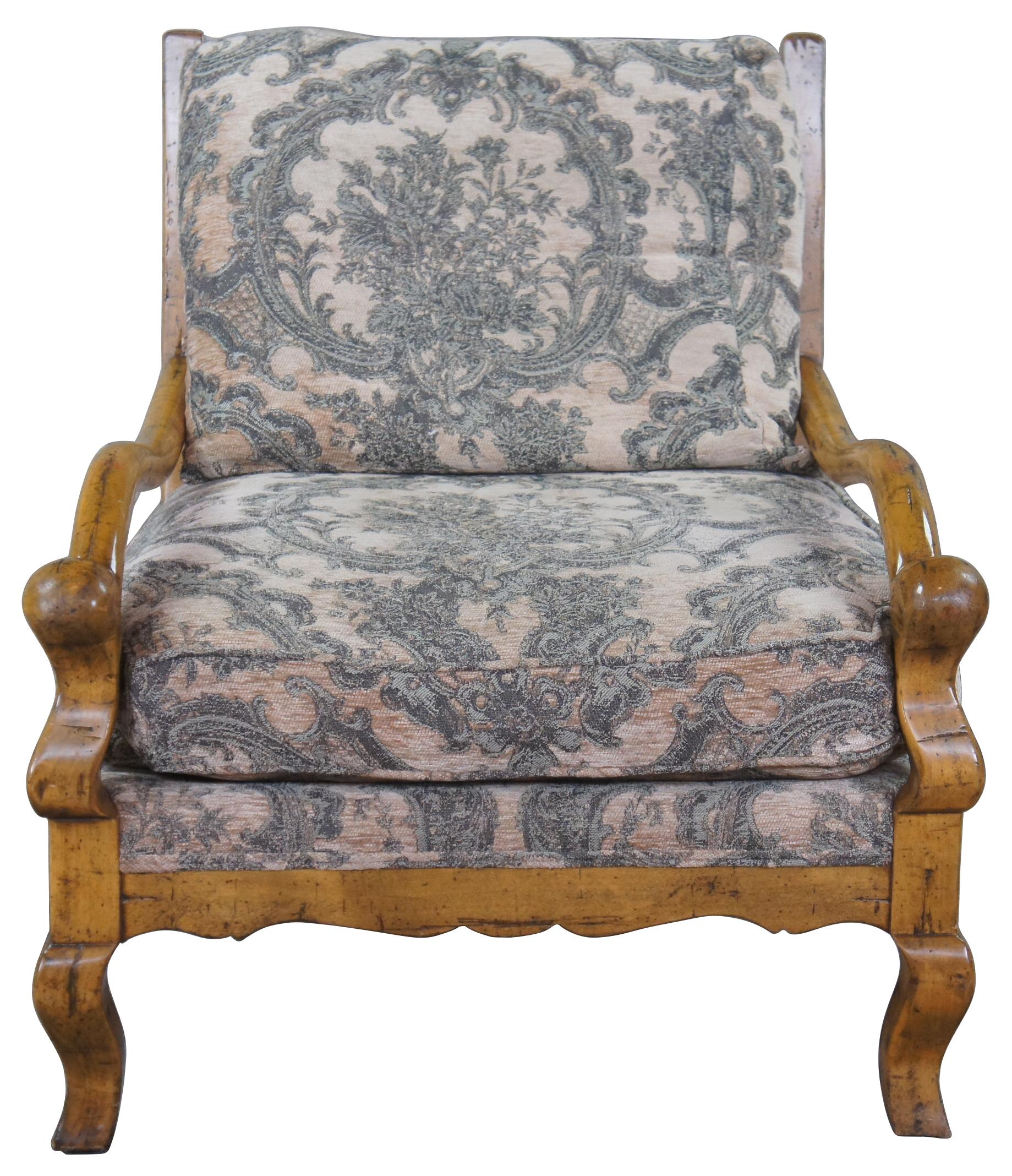 Guy Chaddock upholstery collection knuckle lound chair, UC3001. Features a distresssed hardwood frame with smooth sloping arms, ladderback, serpentine apron and cabriole legs. Upholstered in a brocade style fabric with matching throw pillow.
 