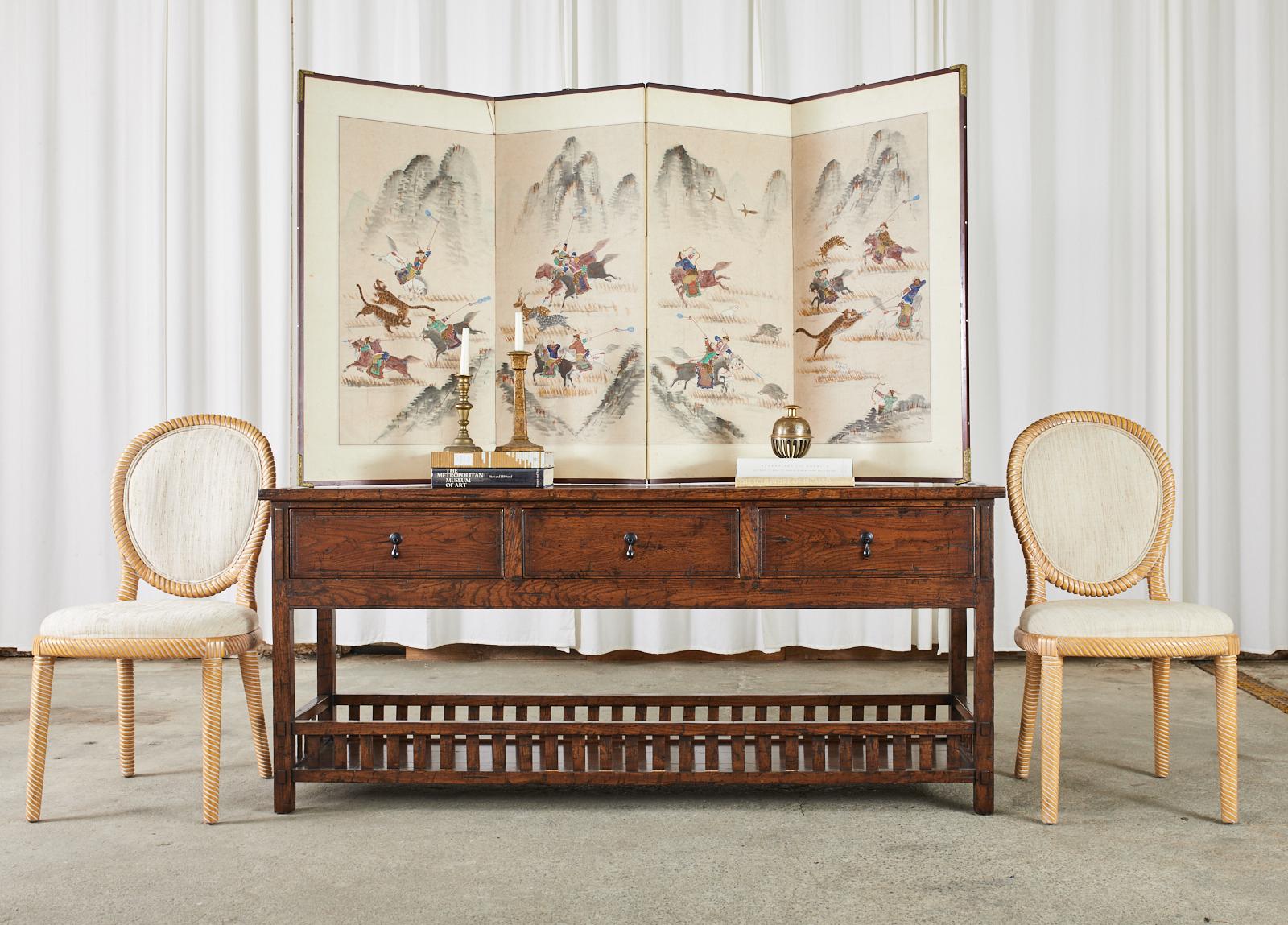 Country English style oak two-tier sideboard server or console table designed by Guy Chaddock. The long server features an exposed mortise and tenon construction on the case made from 1 inch thick planks of oak. Fronted by three large storage