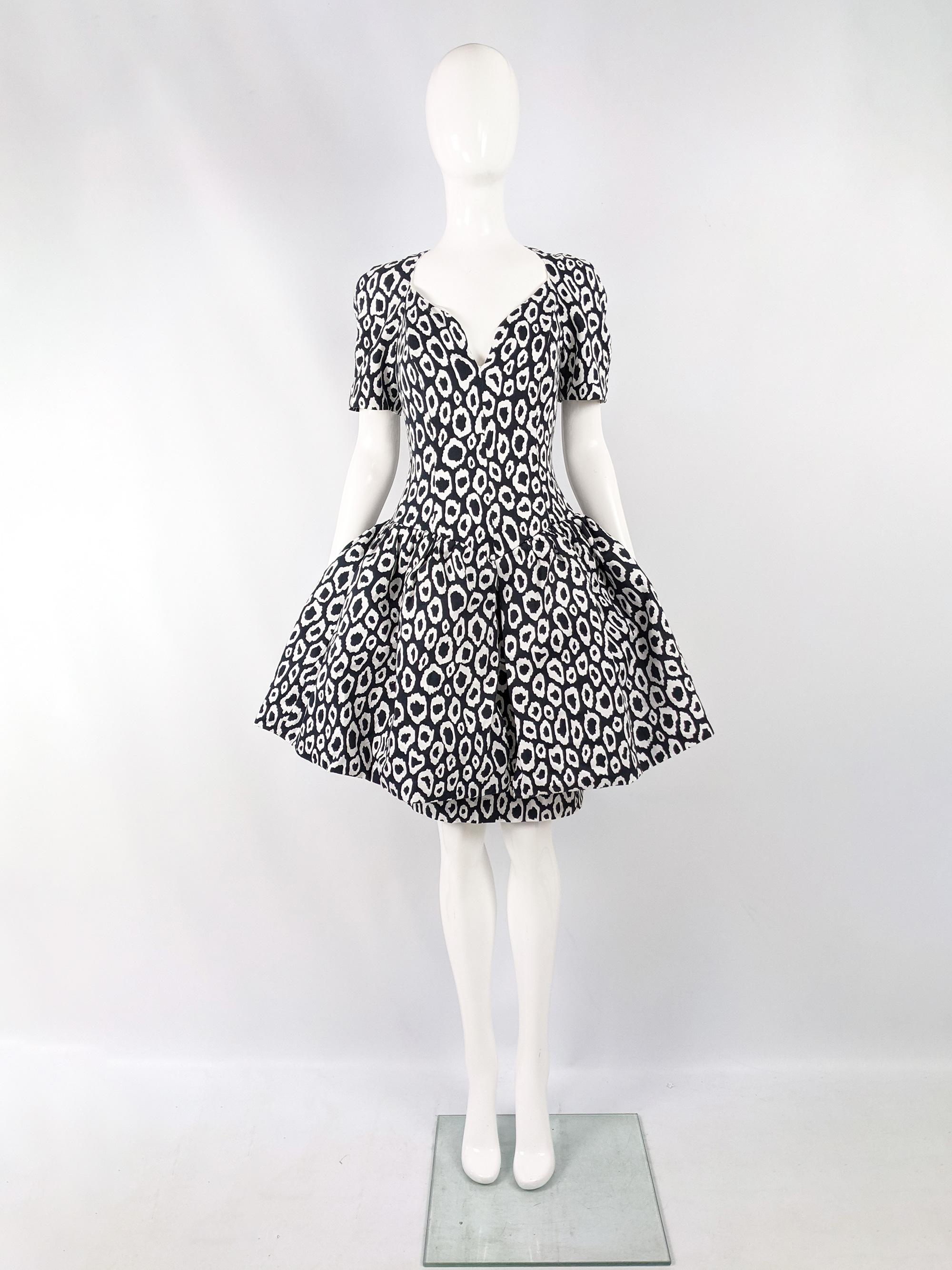 An incredible vintage womens evening / formal party dress from the 80s by luxury French fashion designer, Guy Laroche. In a darkest bluish-grey and white patterned fabric with a layered skirt, the top flared skirt is structured with a horsehair