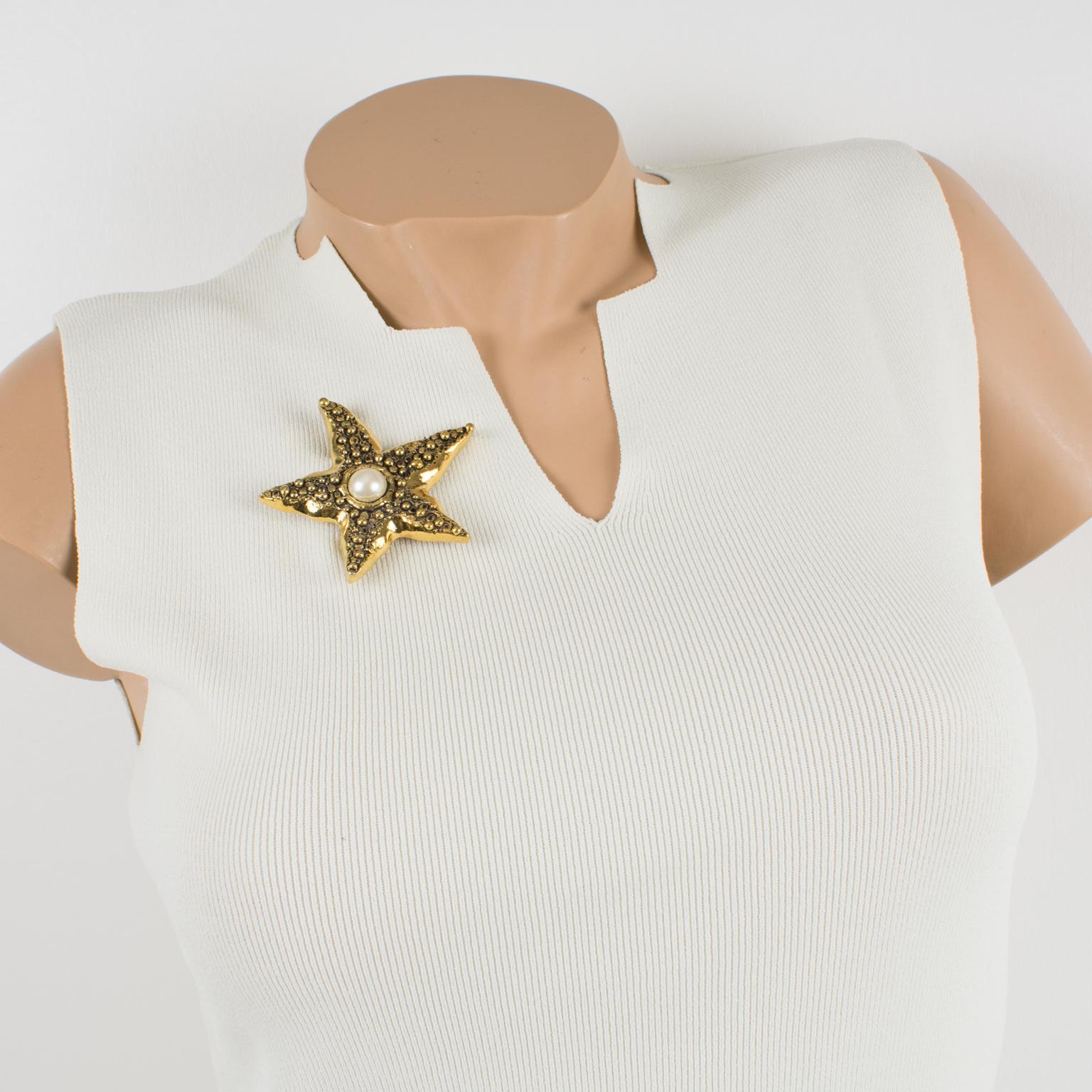 This elegant Guy Laroche Paris pin brooch features an oversized starfish shape with gilt metal, all carved and textured ornate, and pearl-like cabochon. There is the engraved brand signature at the back: 