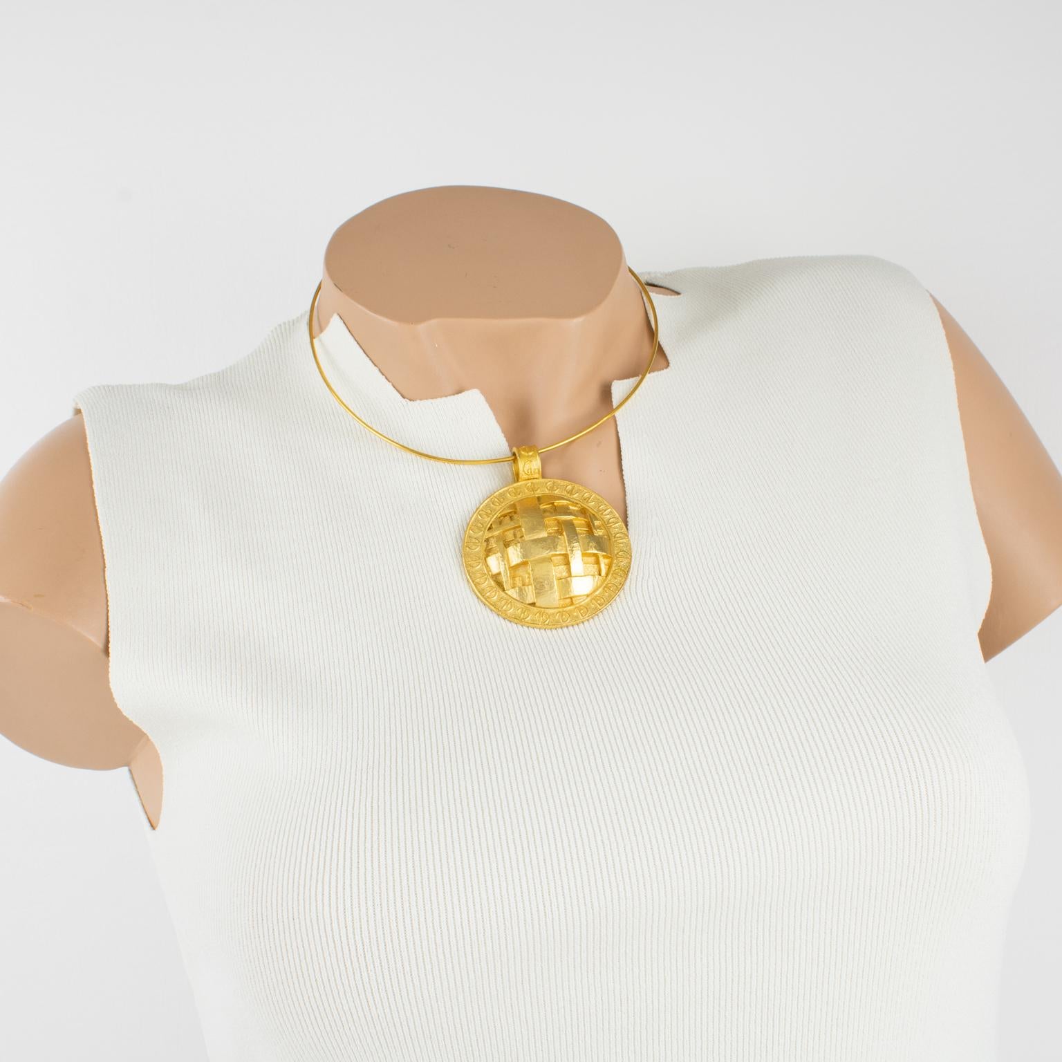 This impressive modernist Guy Laroche Paris signed medallion necklace features a rigid gilt metal collar with a massive gilt metal medallion. The metal medallion is dimensional with a textured design and braided carving topped with the 