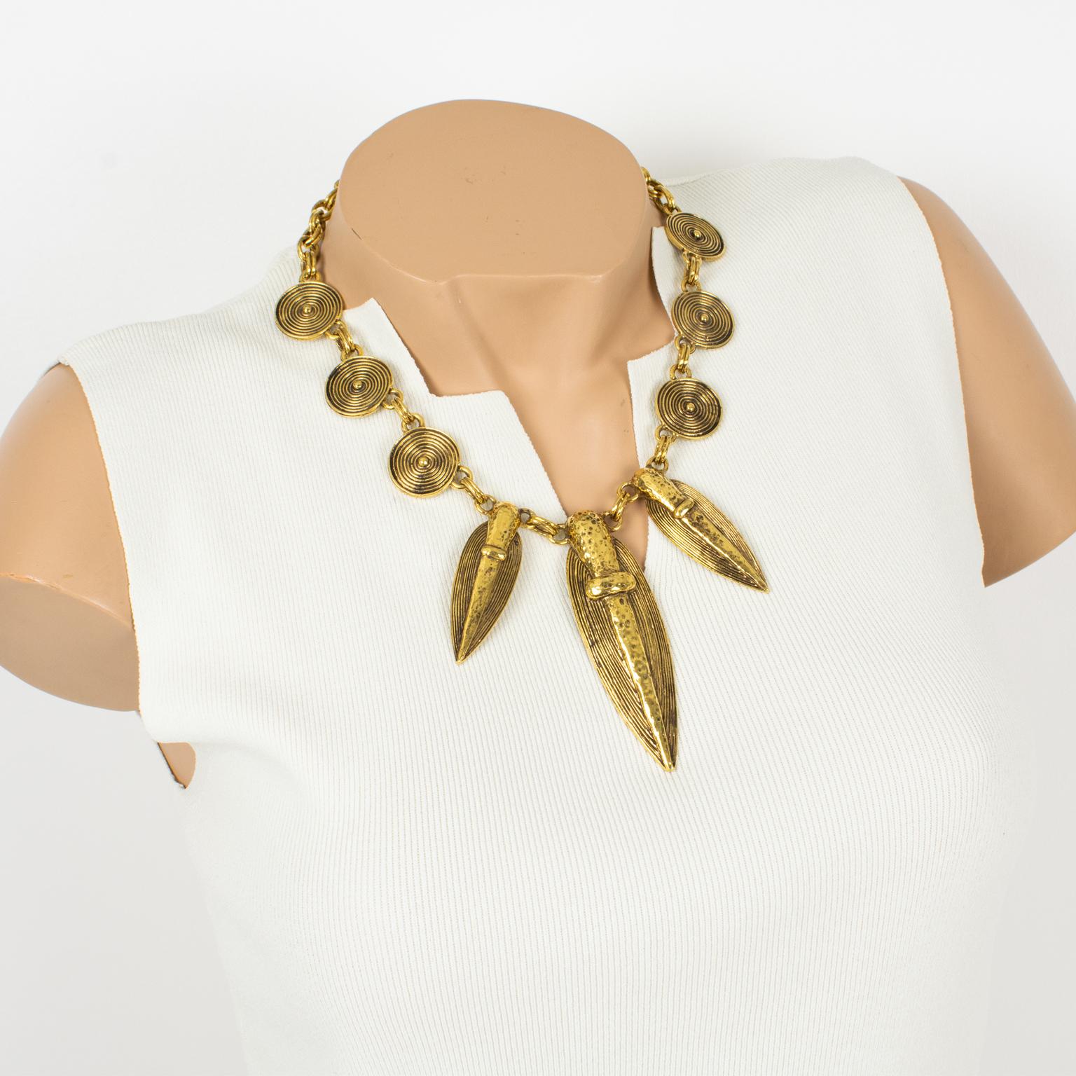 Guy Laroche Paris designed this refined tribal choker necklace in the 1990s. The dangling design features South American-inspired charms design, possibly Pre-Colombian with carved and textured gilt metal. The heavy gilded metal double-strand chain
