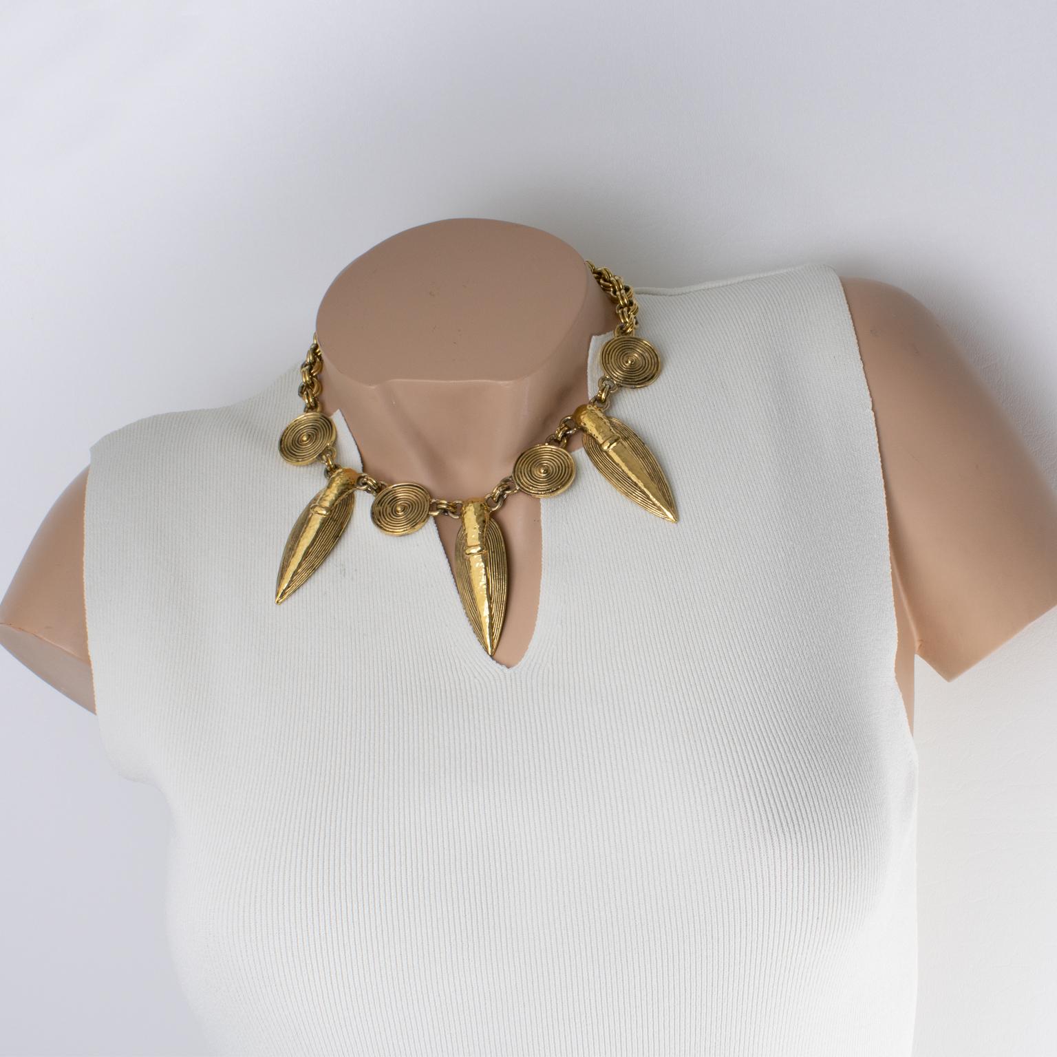 Guy Laroche Paris designed this sophisticated tribal choker necklace in the 1990s. The dangling design features South American-inspired charms design, possibly Pre-Colombian with carved and textured gilt metal. The heavy gilded metal double-strand