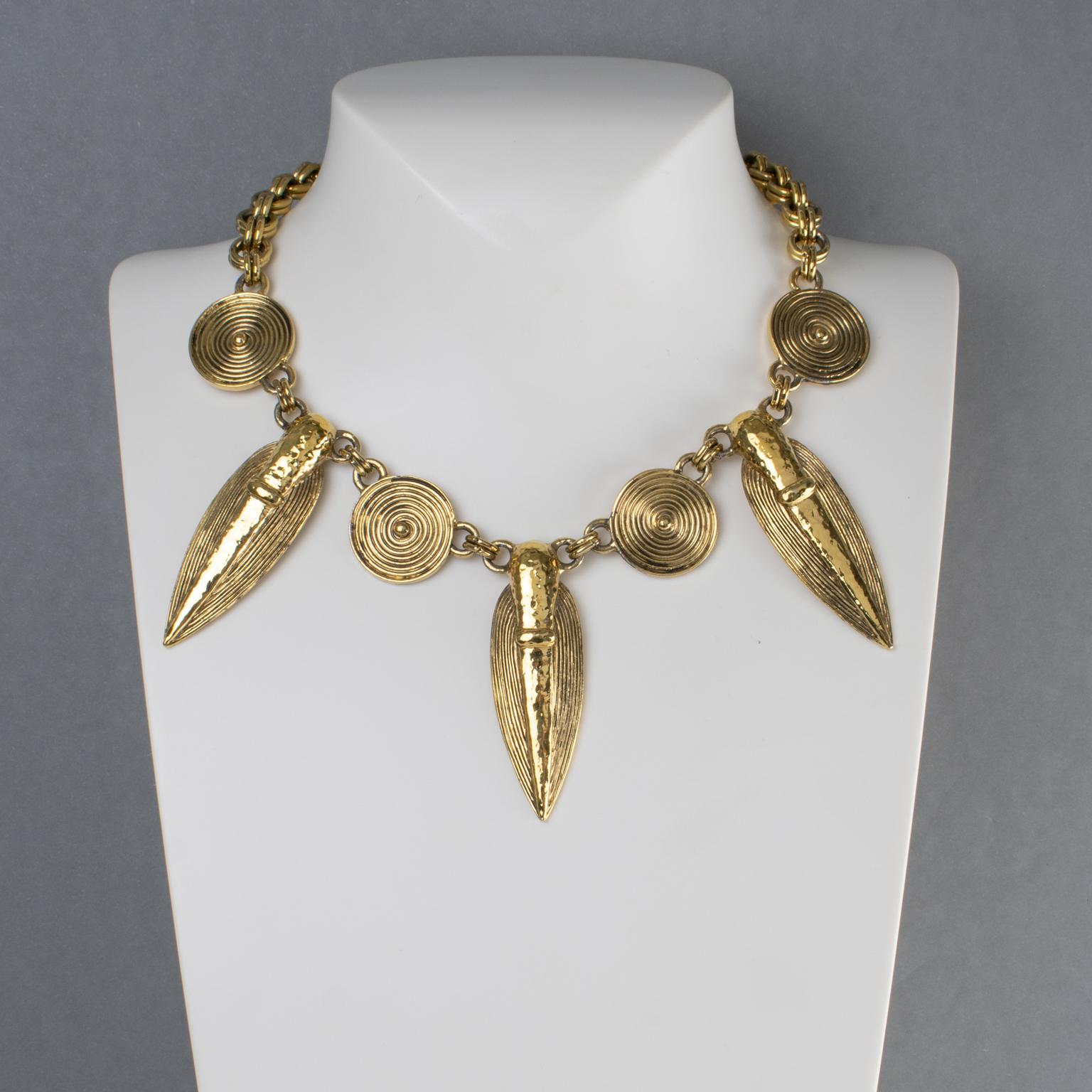 Guy Laroche Paris designed this sophisticated tribal choker necklace in the 1990s. The dangling design features a South American-inspired charm design, possibly Pre-Colombian, with carved and textured gilt metal. The heavy gilded metal double-strand