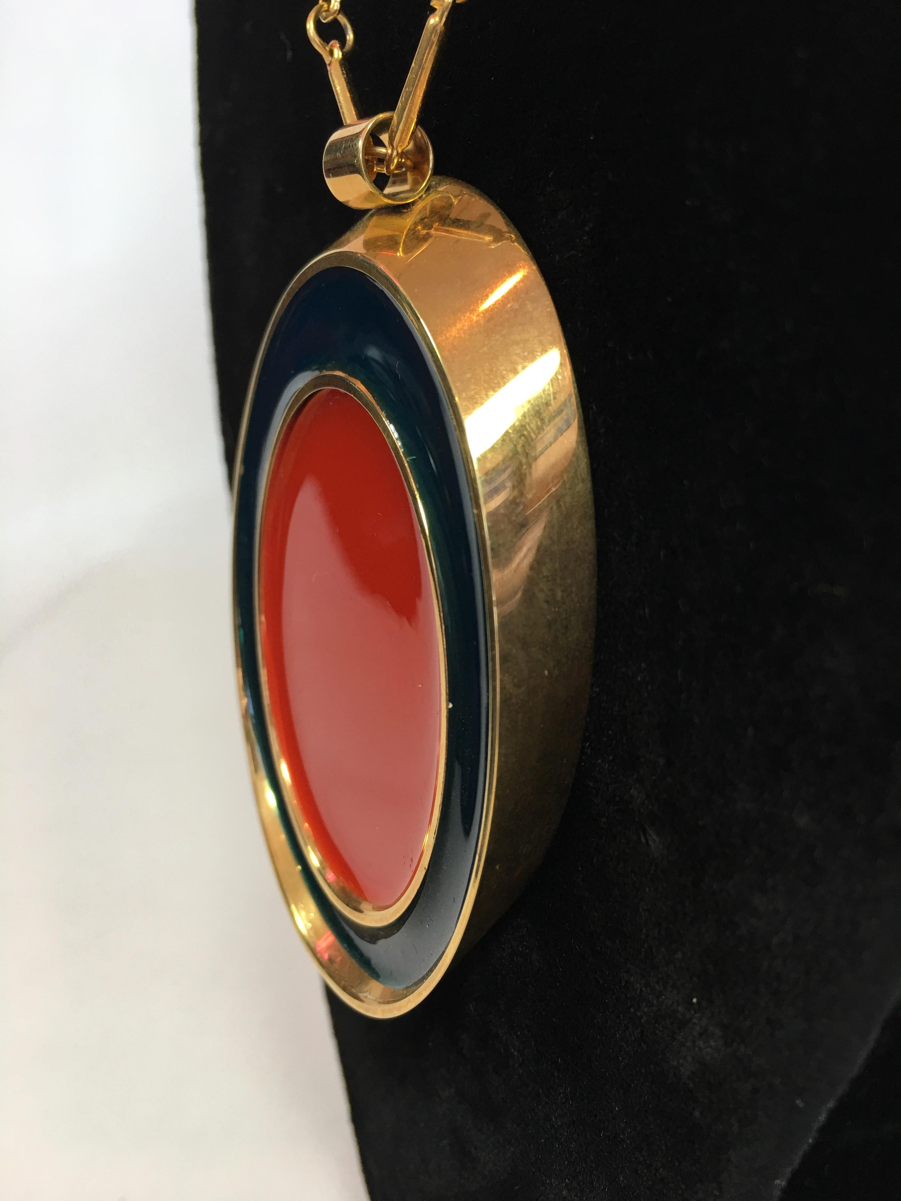Guy Laroche Gold Tone Necklace with Red + Navy Enamel Plated Oval Pendant from the 1960's. Pendant is reversible and is the same Navy + Red design on both sides. Chain is part of the design feature. Guy Laroche tag at the back neck hook. See photo.