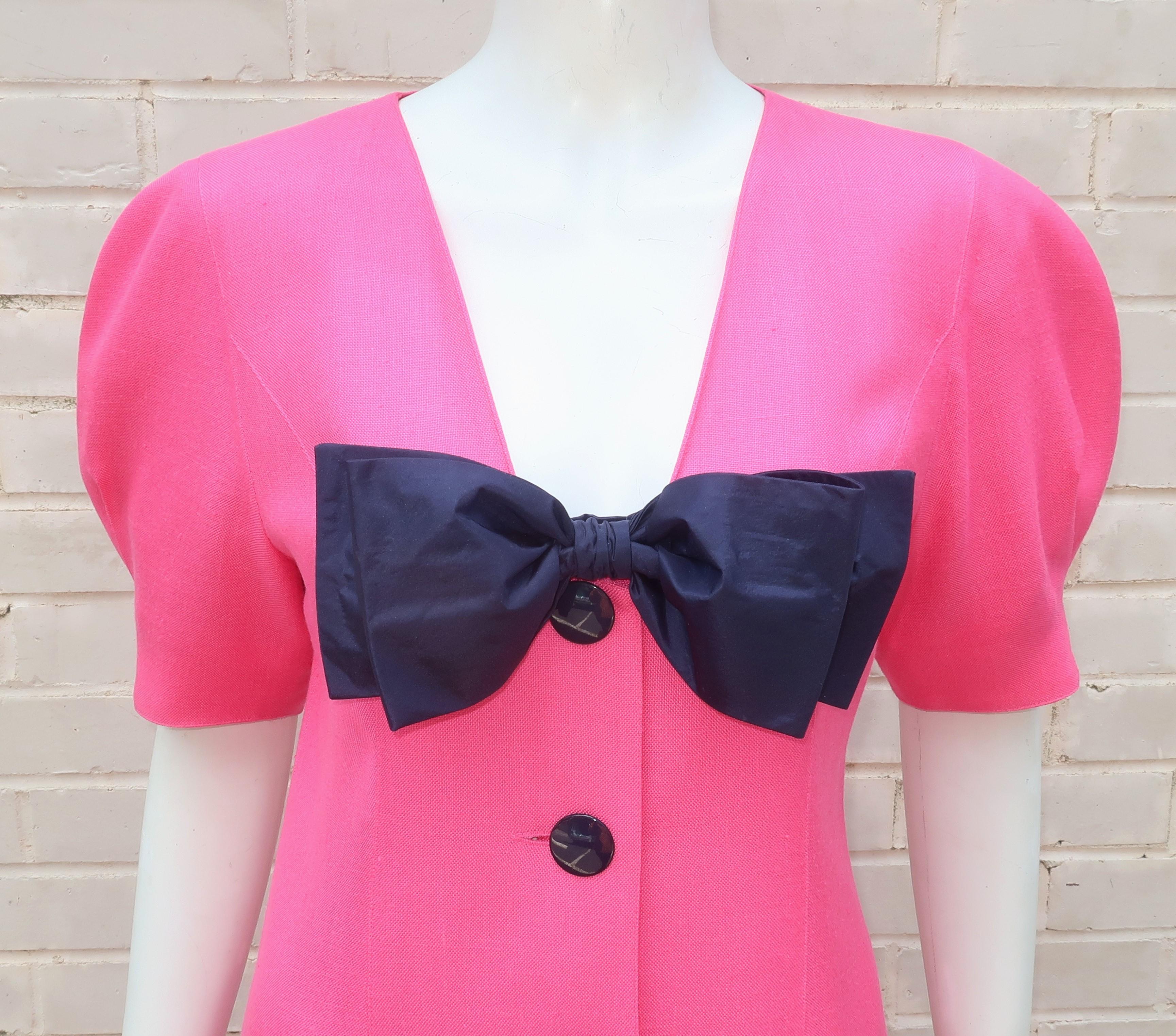 Guy Laroche puts a bow on it with this 1980's hot pink viscose rayon dress with the look and feel of nubby linen accented with a removable blue taffeta bow. The dress buttons down the front with a row of shiny blue buttons and sports short sleeves