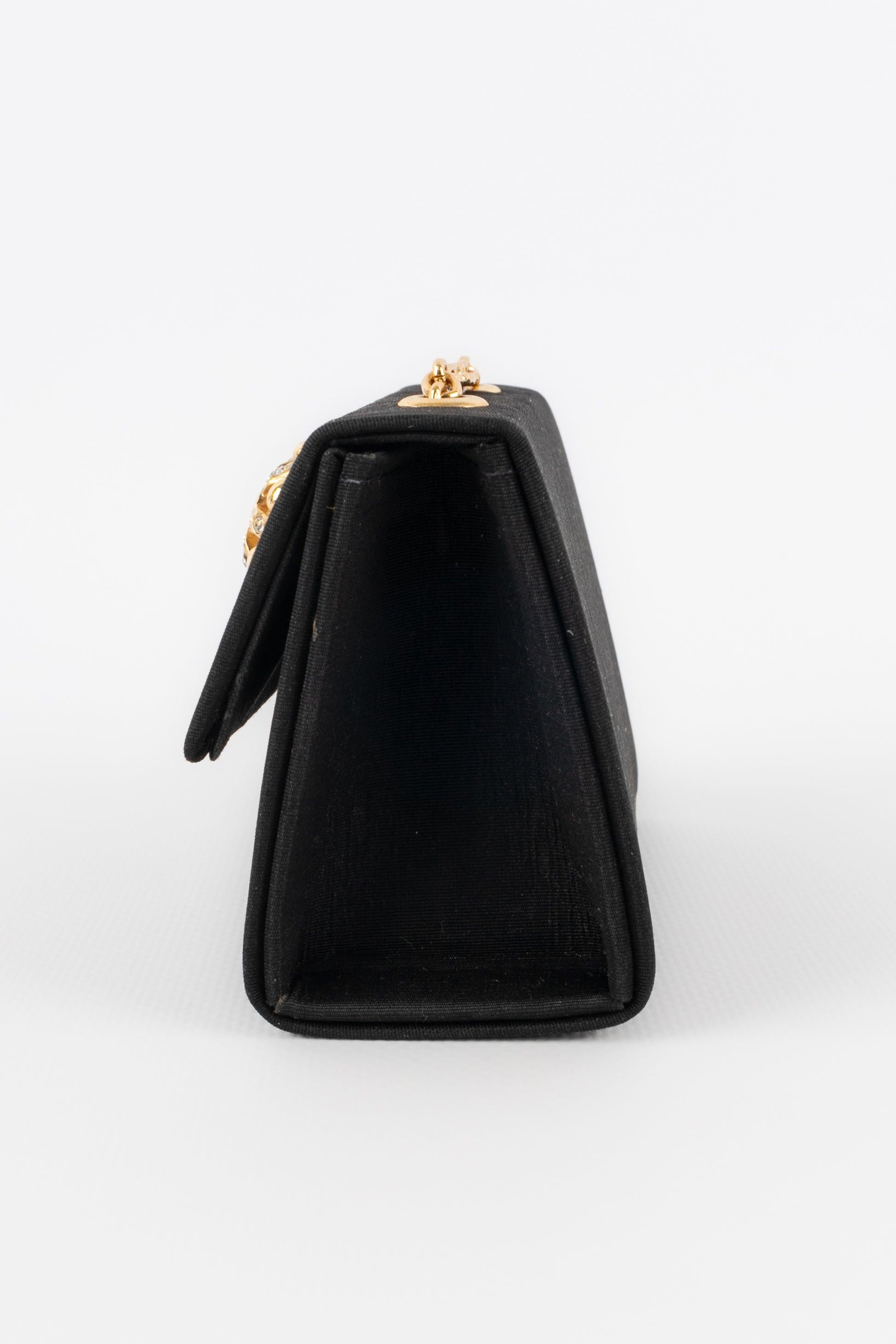 Guy Laroche - Black canvas mini bag with golden metal elements from the 1990s.

Additional information:
Condition: Very good condition
Dimensions: Height: 8 cm - Width: 11 cm - Depth: 5 cm - Handle: 115 cm
Period: 20th Century

Seller Reference: S145