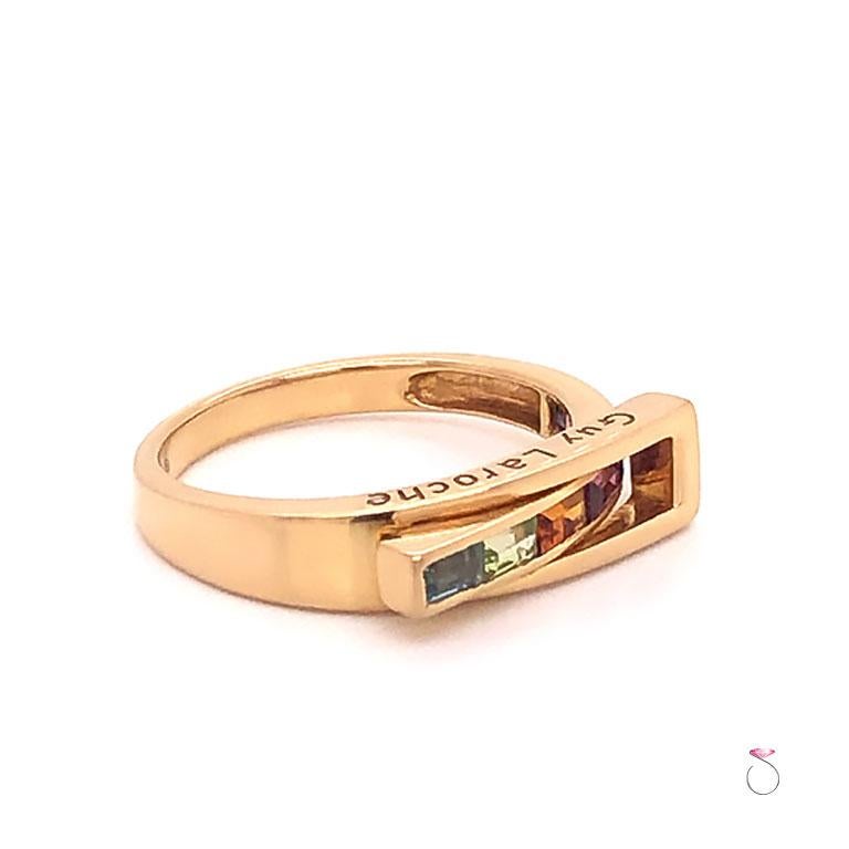 French Designer Guy laroche MultiGemstone band ring in 18k yellow gold. This beautifully designed band features a gorgeous line of channel set Gemstones in a rainbow of colors. The band has a unique pass through design. The ring is masterfully
