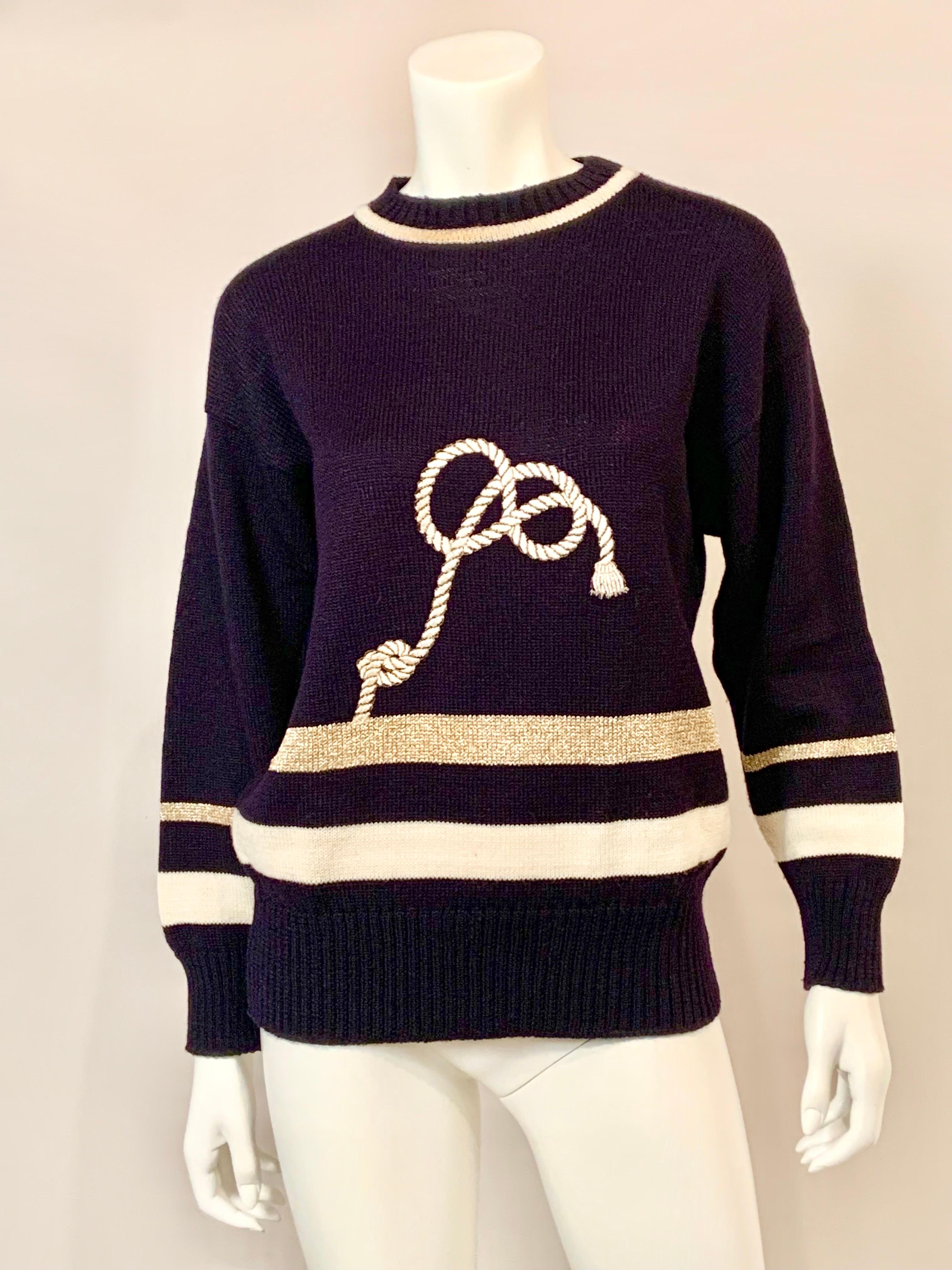 Dieser bezaubernde Guy Laroche Pullover mit maritimem Thema ist marineblau und hat ein weißes Band am Halsausschnitt, an den Ärmeln und am Saum. Der Glamour 
kommt von dem goldenen Metallic-Band an den Ärmeln und oberhalb des Saums sowie dem weißen,