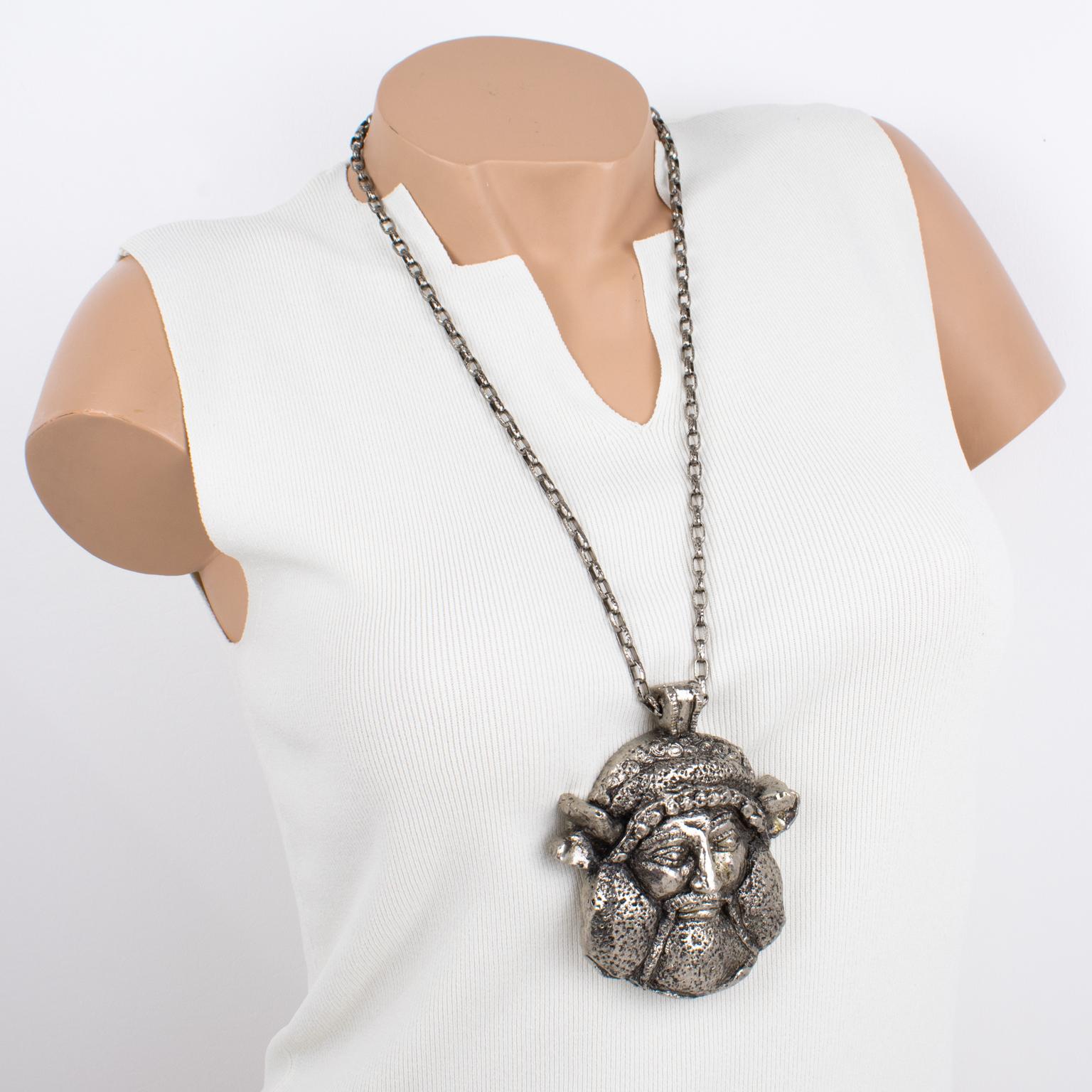 This stunning Guy Laroche Paris signed pendant necklace features an extra-long silvered metal textured chain with a massive dimensional pendant. The medallion boasts an antique Viking god face in silvered metal-coated resin. The engraved signature