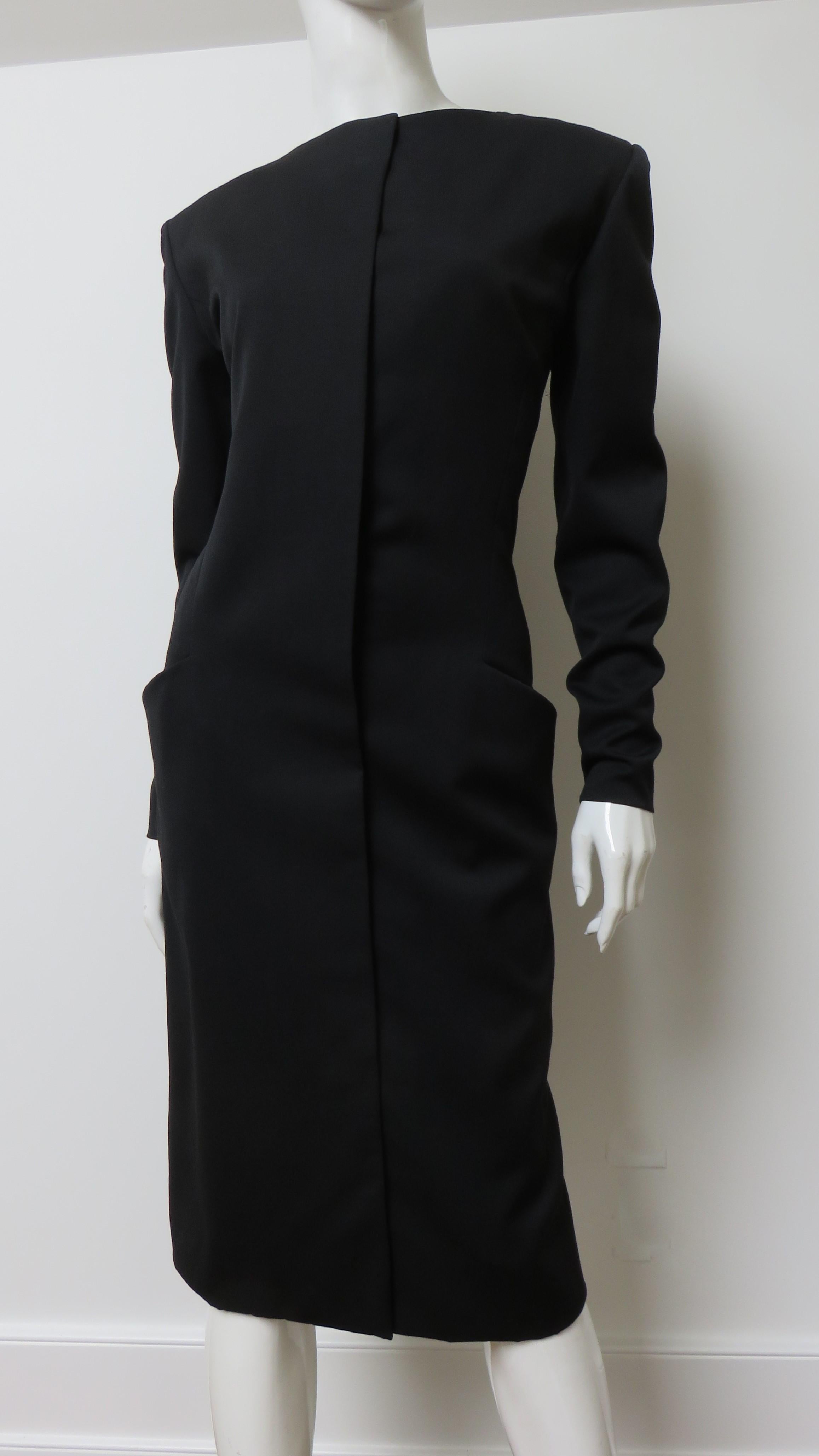  A fabulous black silk dress by Guy Laroche.  It it is semi fitted with long sleeves with zippers at the wrists, light shoulder padding and front hip pockets incorporated into the princess seaming.  The fabulous dramatic back of the dress has lacing