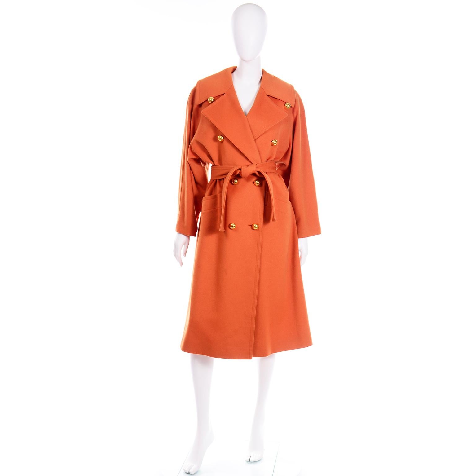 This is a gorgeous orange wool cashmere blend vintage 1980's Guy Laroche double breasted trench coat with round gold buttons. There are two functional front pockets and shoulder pads for structure. We especially love the box pleat along the back
