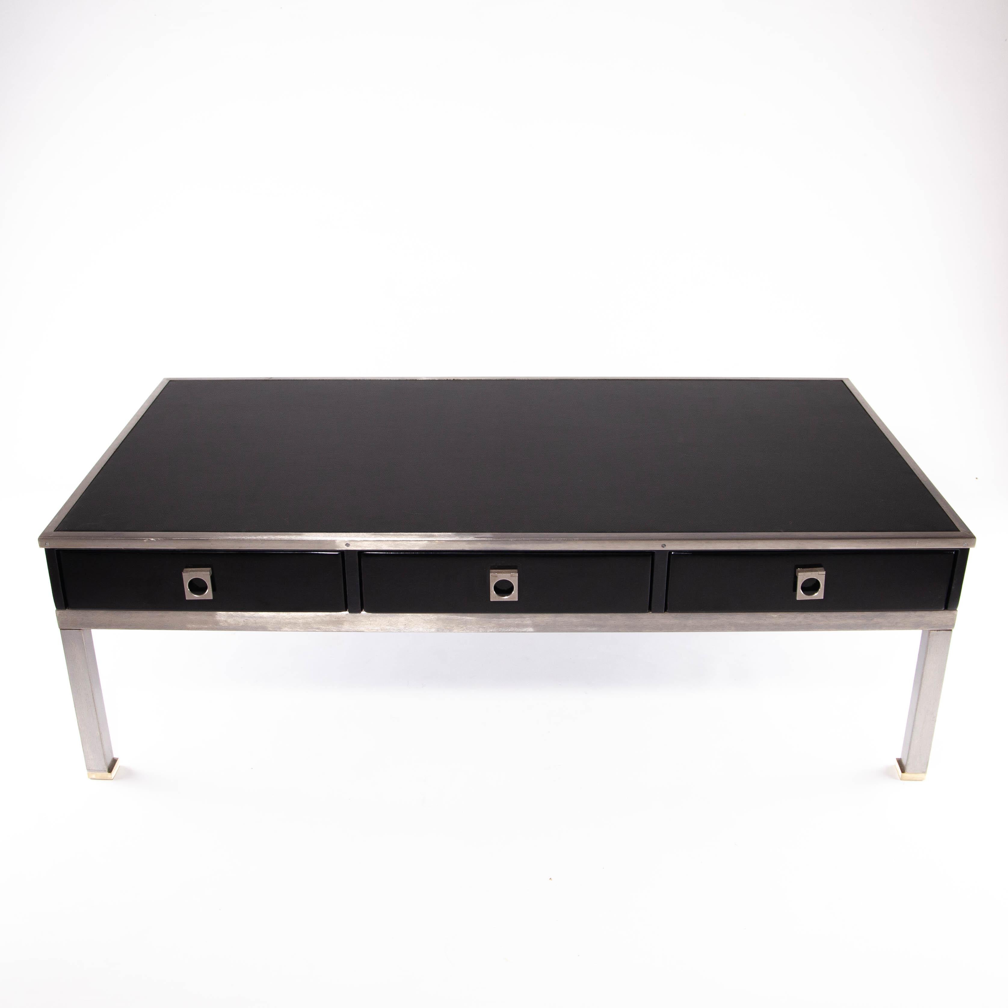 Mid century Guy Lefevre coffee table completely restored. Faux leather top with 3 lacquered drawers. Brushed steel legs with a little touch of gold at the lowest part. Probably edited by Maison Jansen