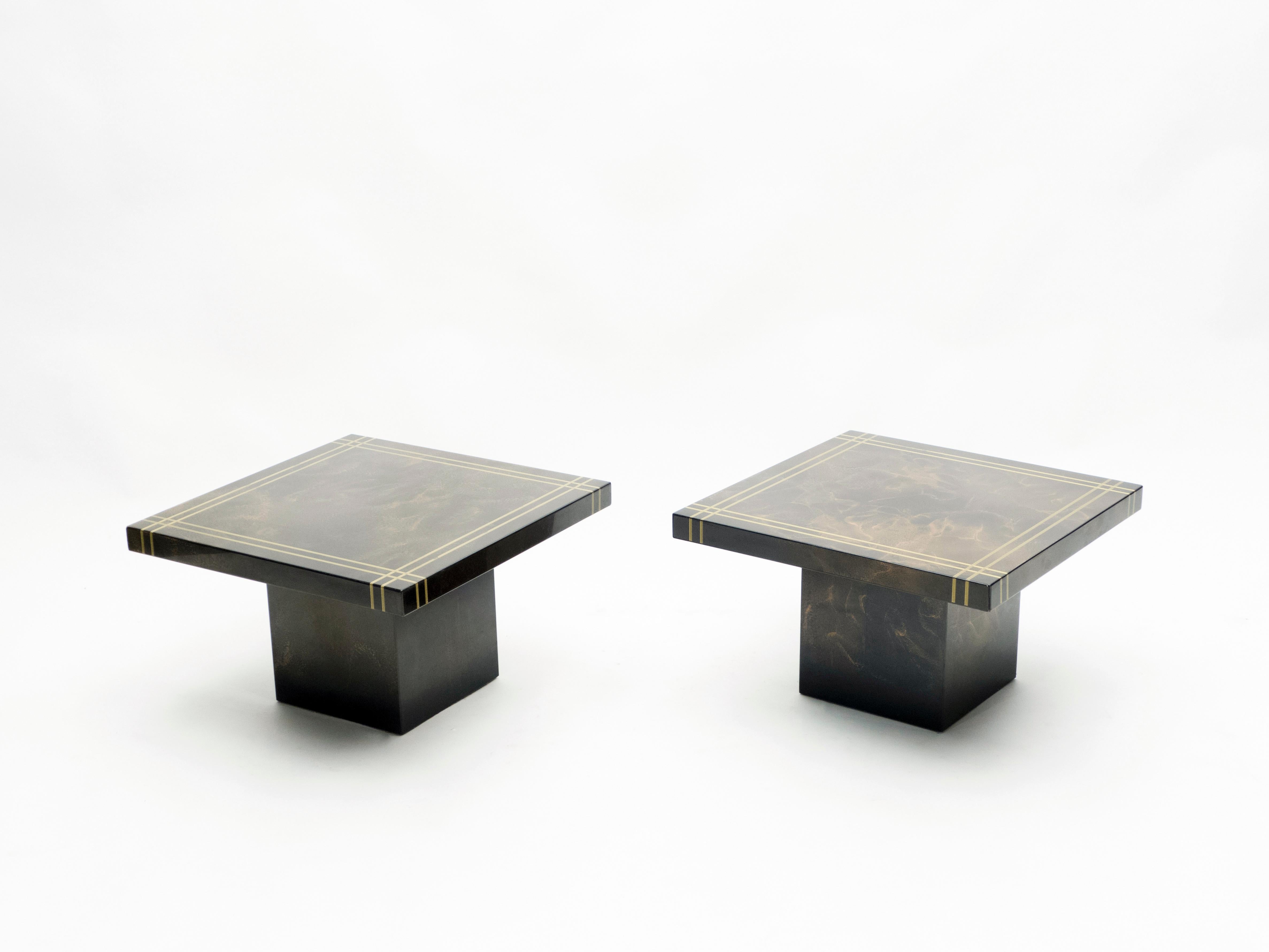 The boxy, clean design of these end tables, by Guy Lefevre for Ligne Roset, balances the best of Mid-Century Modern design with a contemporary look. The large squared surface is lacquered in shades of bronze, appearing dappled, with light patches
