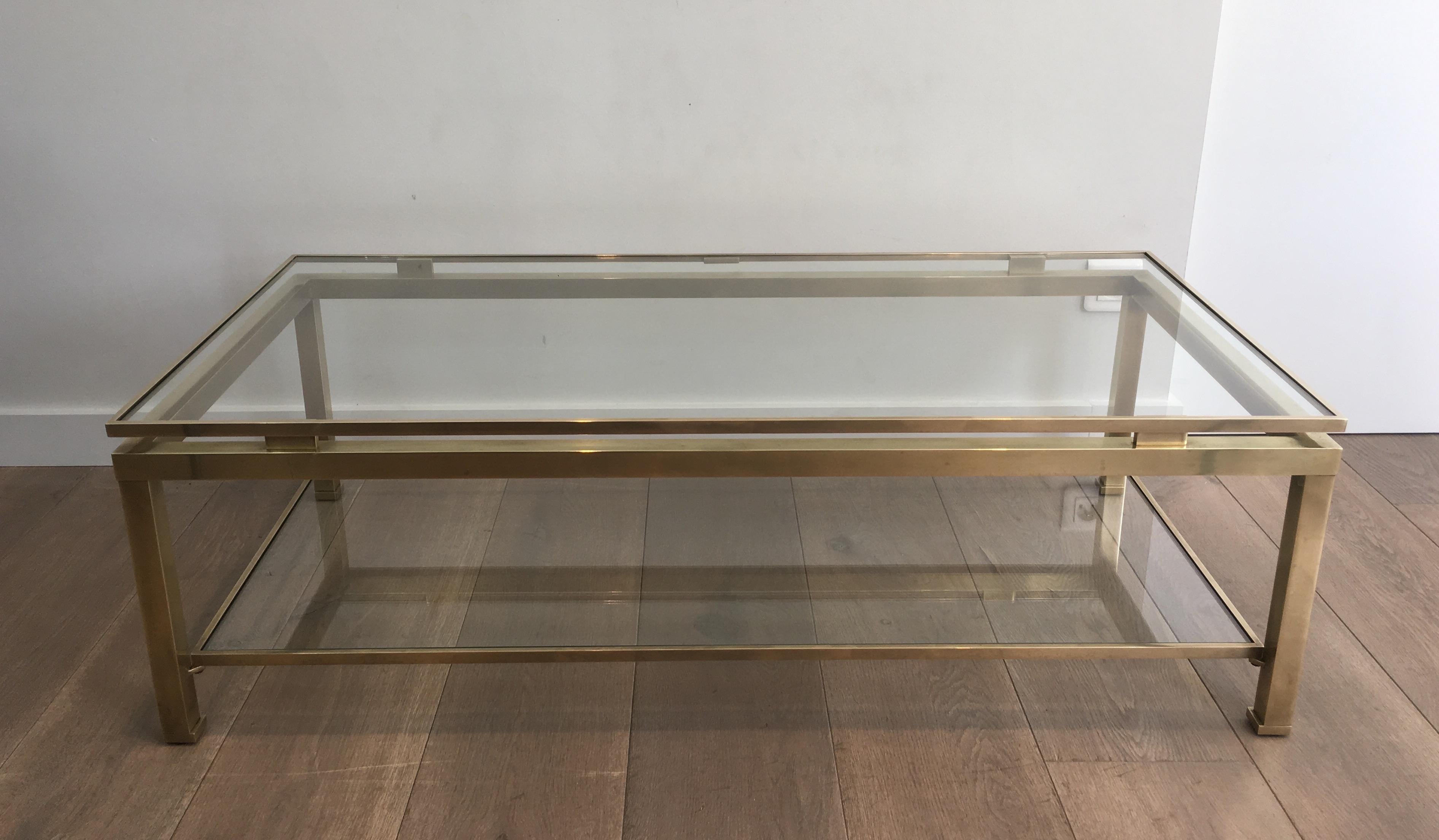This coffee table is made of brass with 2 glass shelves. This is a beautiful model by famous French designer Guy Lefèvre for Maison Jansen, circa 1970.