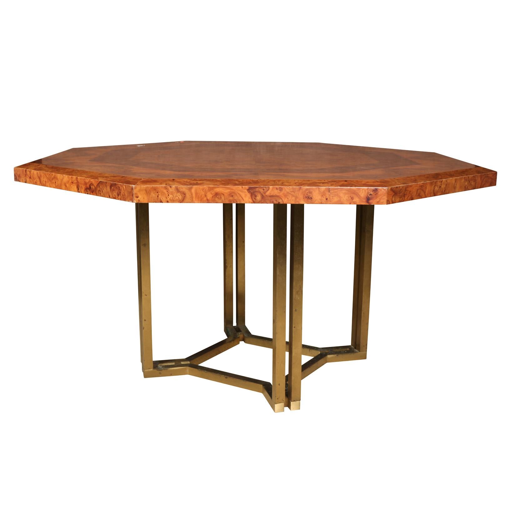 A vintage Guy Lefevre for Maison Jansen octagonal dining table with a four sided geometric brass base. Table has a geometric concentric pattern with a burled wood, two tone top.