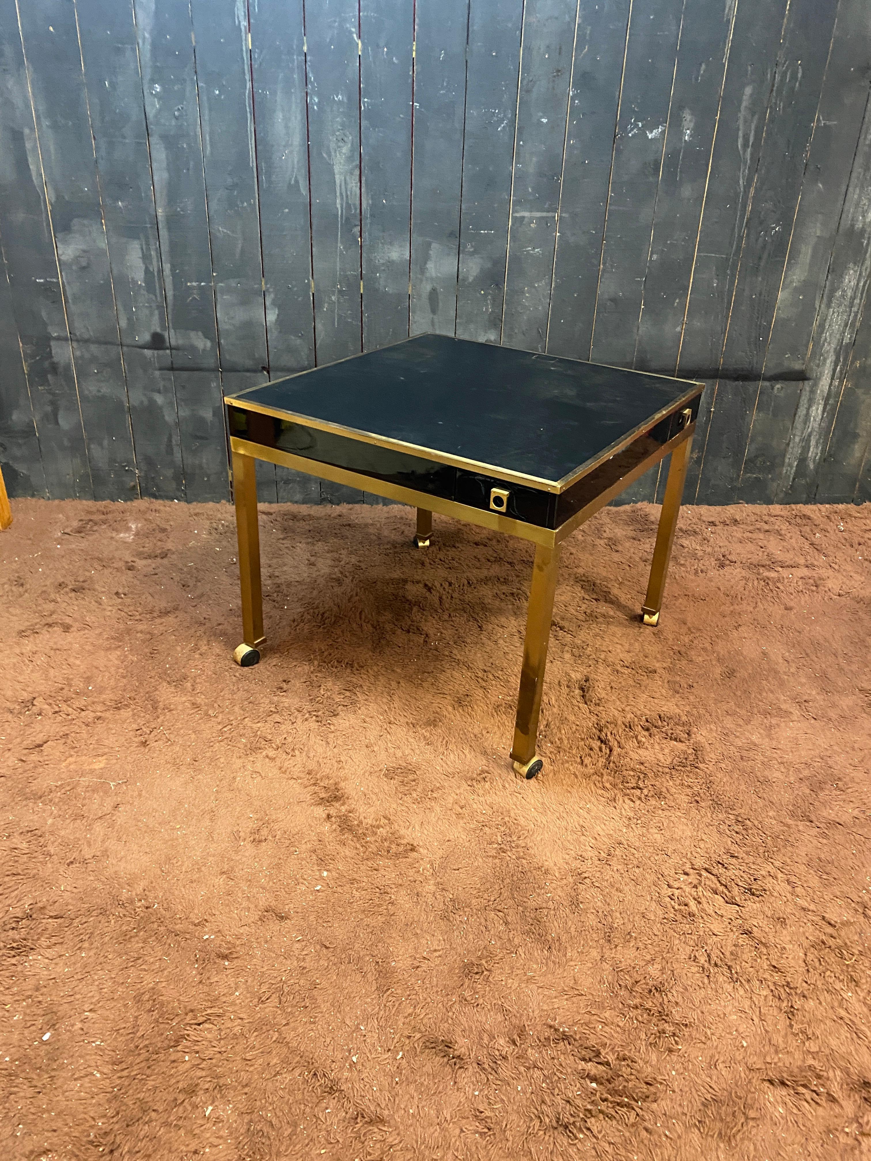 Guy LEFEVRE, game table in brass, lacquered wood and imitation leather
casters
with 4 small drawers allowing, among other things, to place your glass