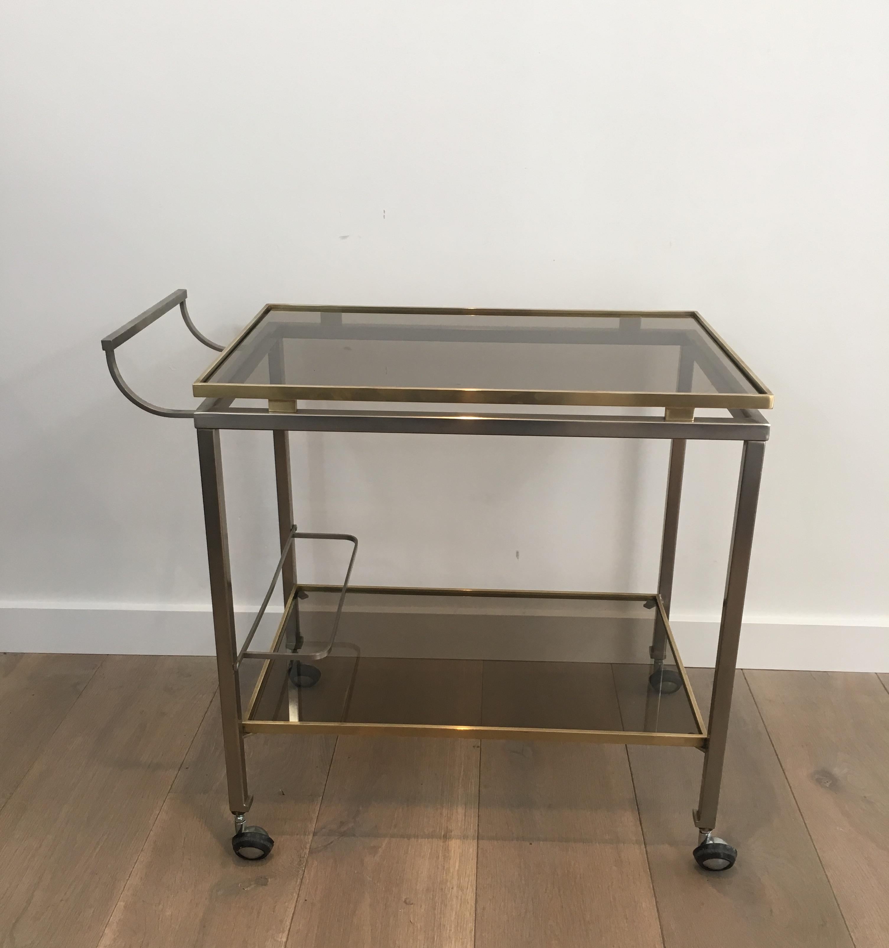 This brass trolley is made of brushed steel and brass with smoked glass shelves. This drinks trolley is a rare model by famous French designer Guy Lefèvre for Maison Jansen, circa 1970.