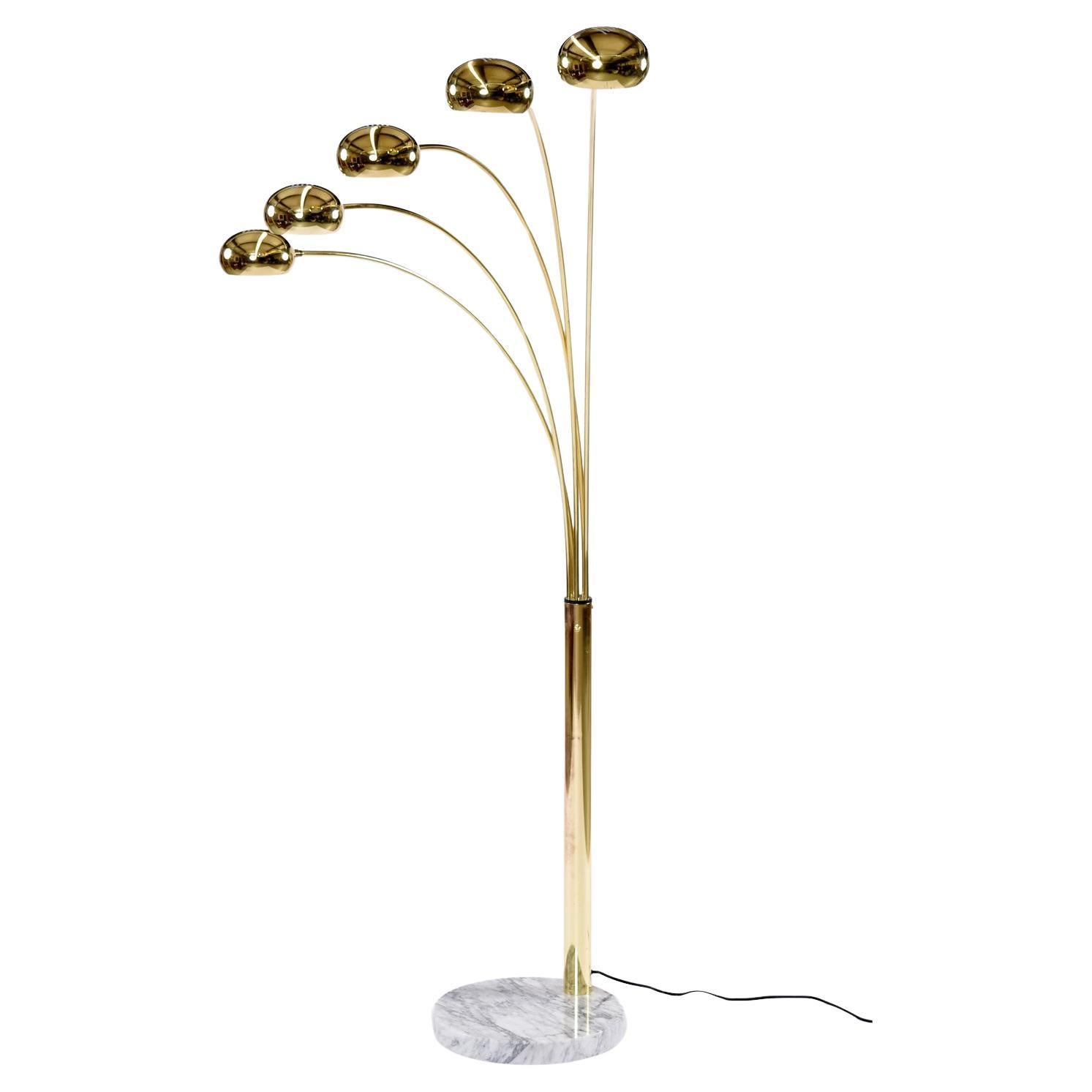Una spessa e pesante base in marmo bianco/grigio sostiene questa elegante lampada ad arco a forma di polipo color oro.  L'elegante metallo dorato lucido ha un aspetto di classe in contrasto con la pietra.  Le cinque teste sono tutte regolabili e