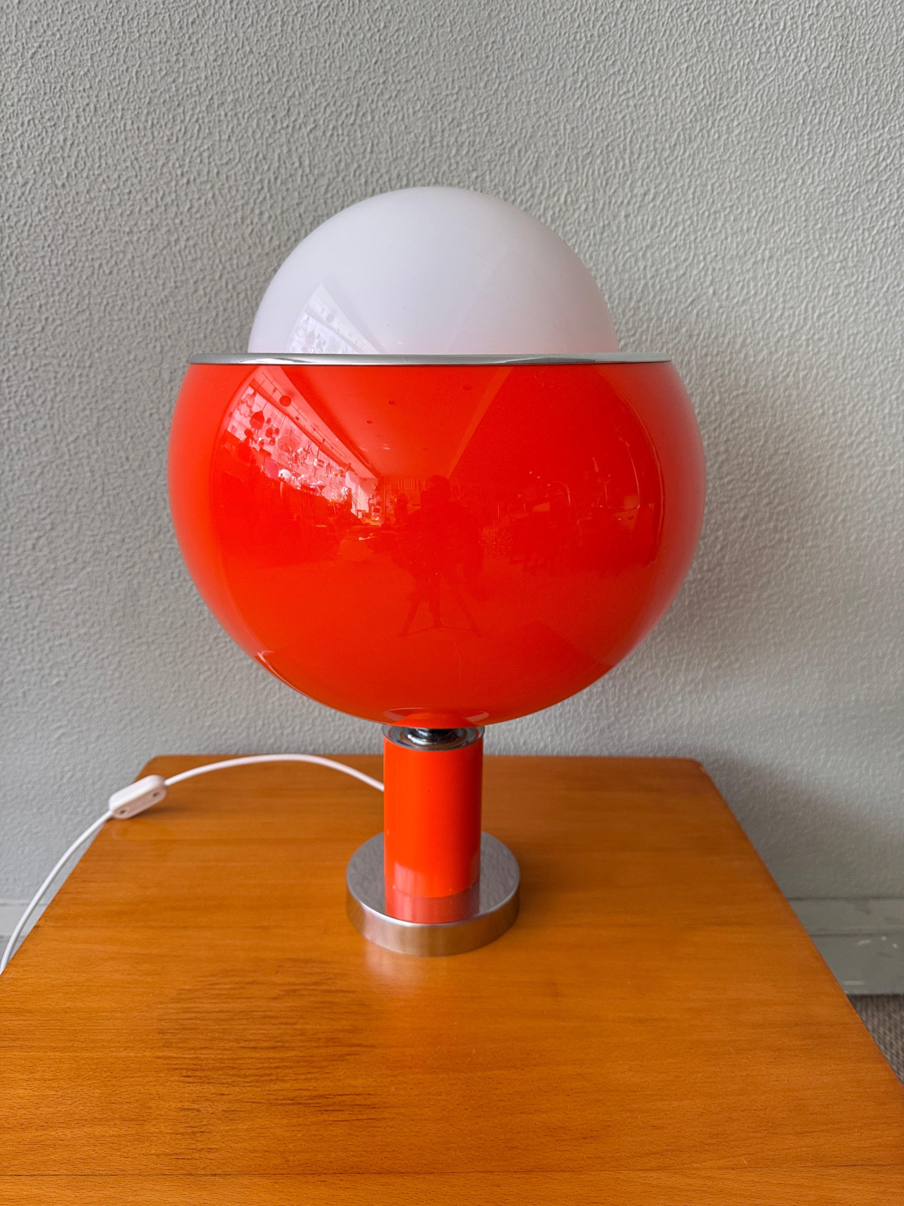 Guzzini Style Table Lamp – 1970s – Orange Acrylic & Opaline Glass

A vibrant expression of 1970s Italian lighting design, this Guzzini-style table lamp features a bold orange acrylic outer shell paired with a delicate internal opaline glass