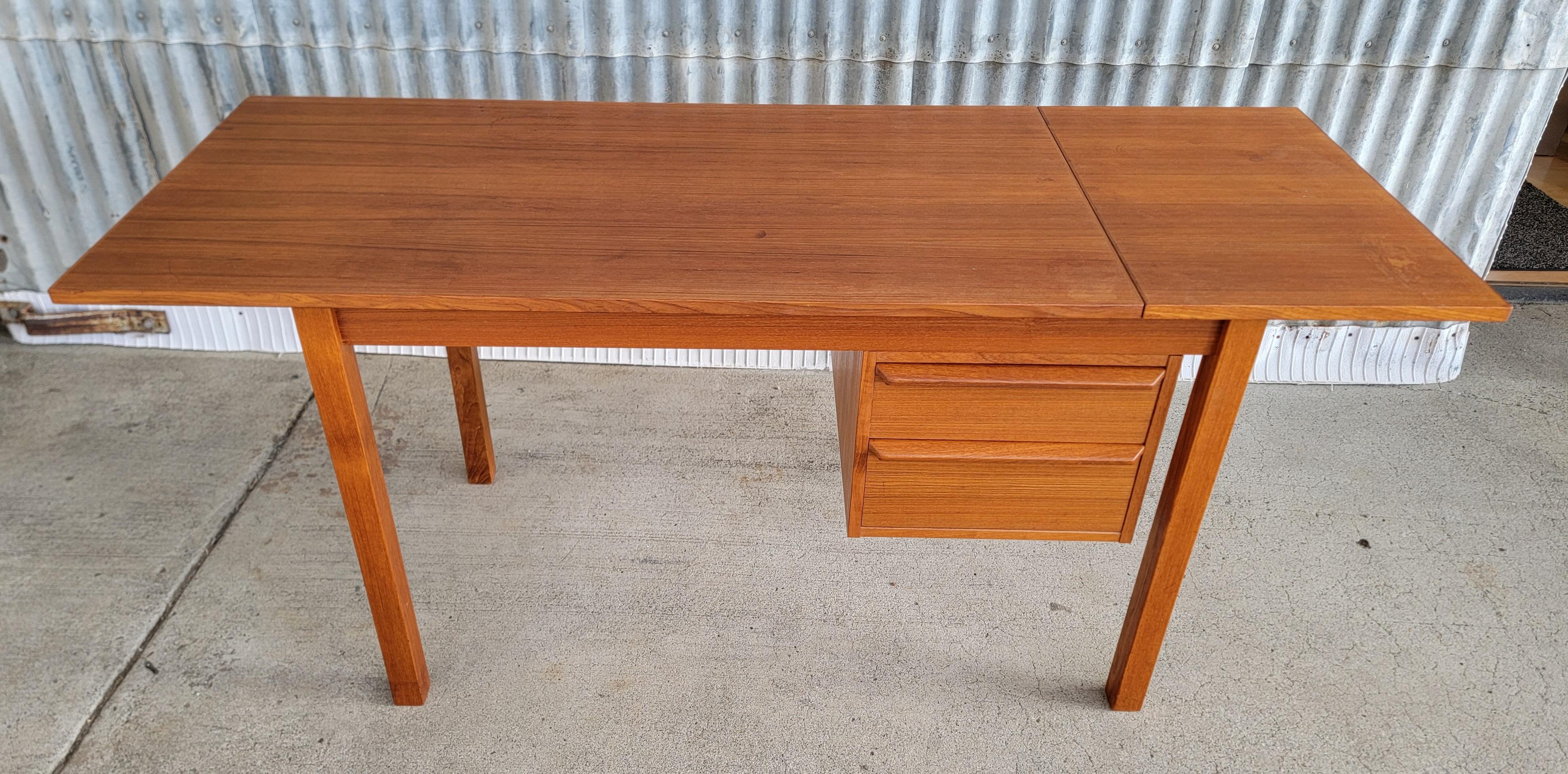 An expanding Danish Modern teak desk made by G.V. Mobler, Denmark, circa. 1970's. Drawer position and desk top surface are adjustable. Drawer bank slides right or left side suitable for right and left hand use. Drop-leaf lifts and slides to expand