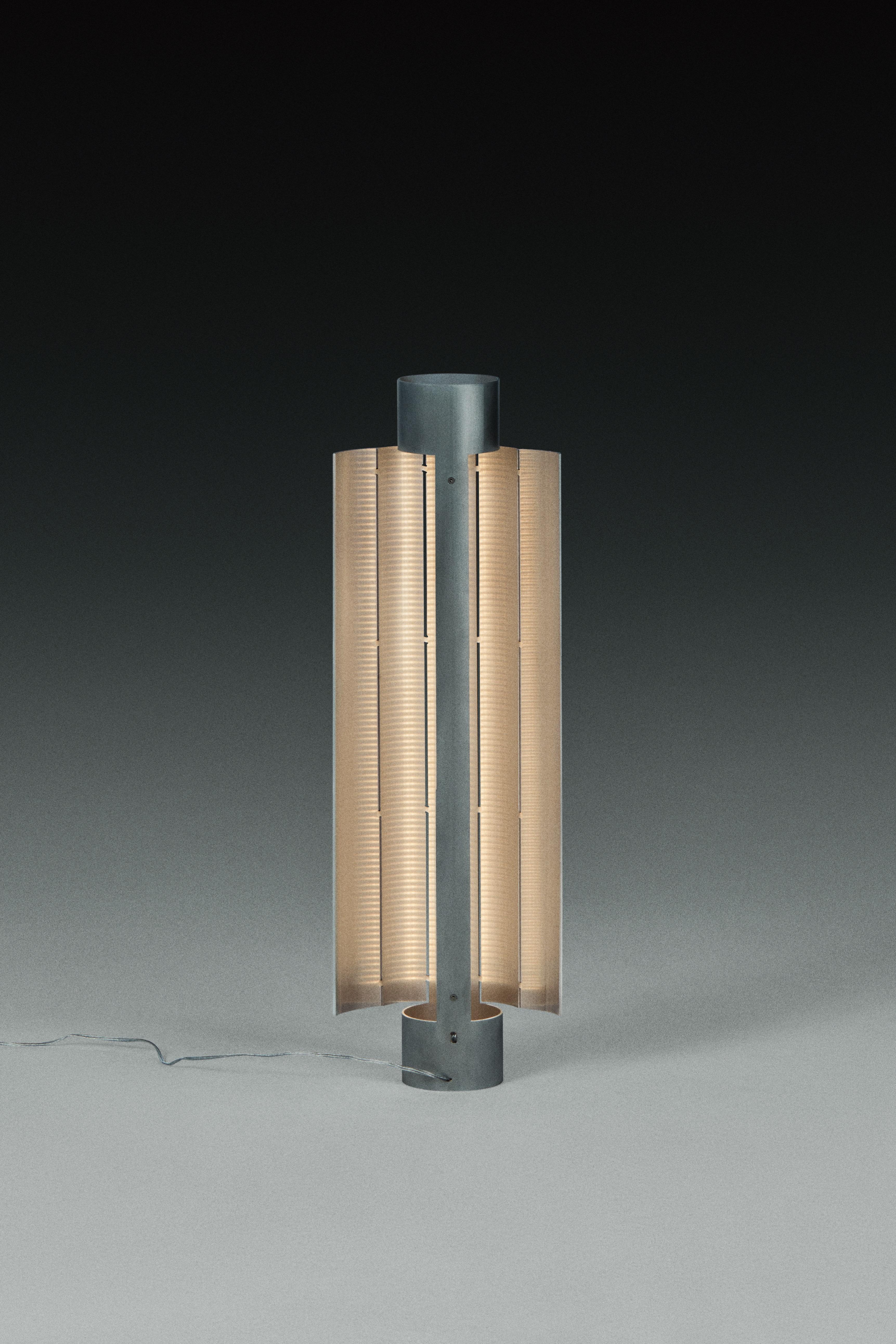 Gvpo Table Lamp by Kutarq Studio
Materials: Aluminum.
Dimensions: D 21 x W 8 x H 56 cm

Matt aluminum, patinated by hand.
Lightsource: 2 x parallel warm LED stripes, IP20 24V 14,4W/m - 72W 2700K, dimmable.

The GVPO Table Lamp is expertly crafted