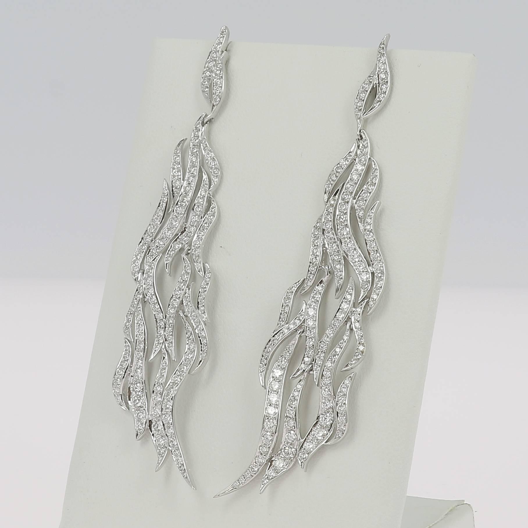 An amazing pendant earrings set with a combination of wavy parts paved with Round Diamonds weighing 3.28 carats
The Diamonds are GVS qualities.
The Drop Leaves Earring is 18K White Gold.