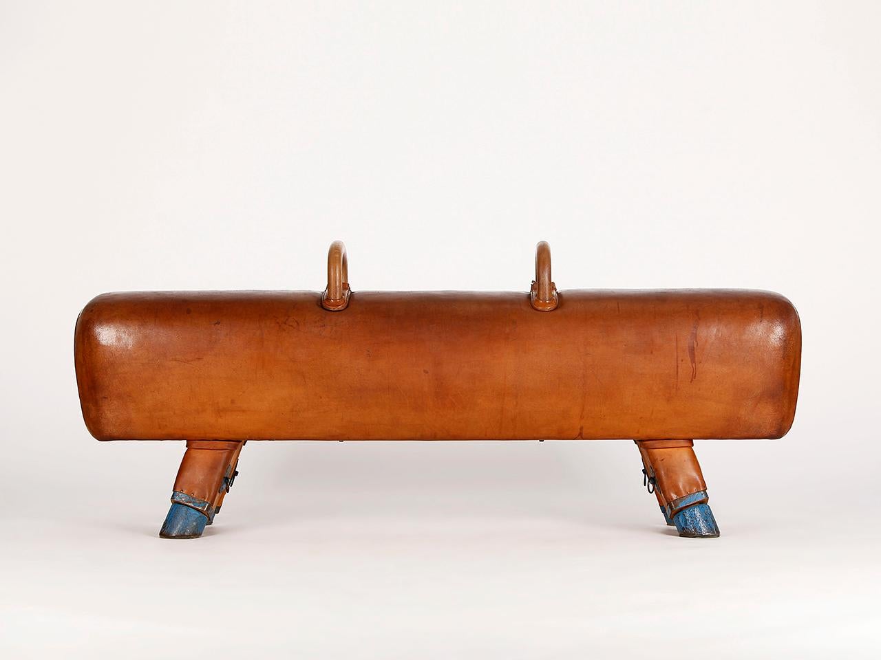 Pommel horse from former Czechoslovakia. The legs were cut to a height of 54cm. The thick leather has been cleaned and the patina was retained. The handles can be removed for comfortable seating. The wooden handles were restored. Very nice Vintage