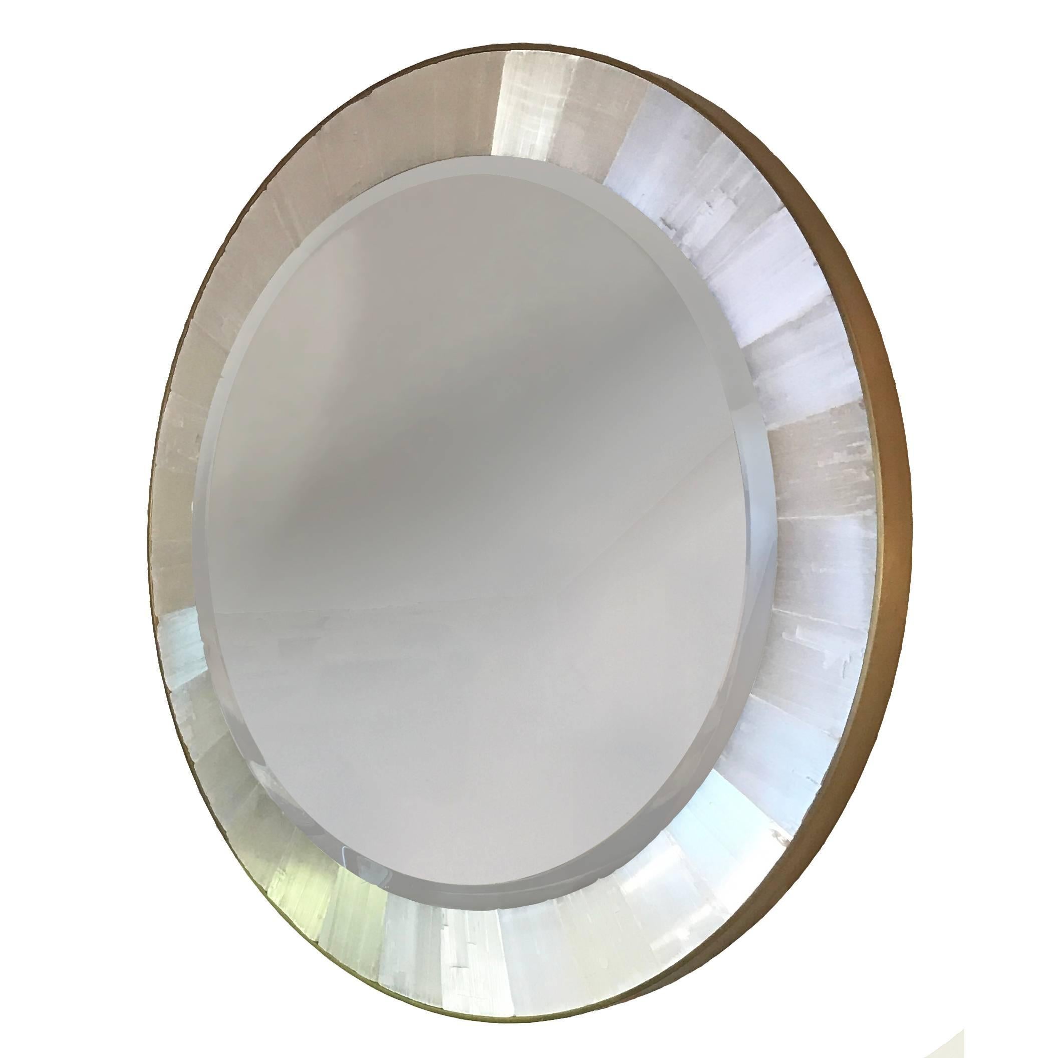 Luminous, snowy gypsum and shining brass frame seamlessly frame a beveled mirror. Circular shaped perfect for a powder or dressing room, custom shapes and sizes available, as well as electrical hard-wiring for internal illumination. Date of creation