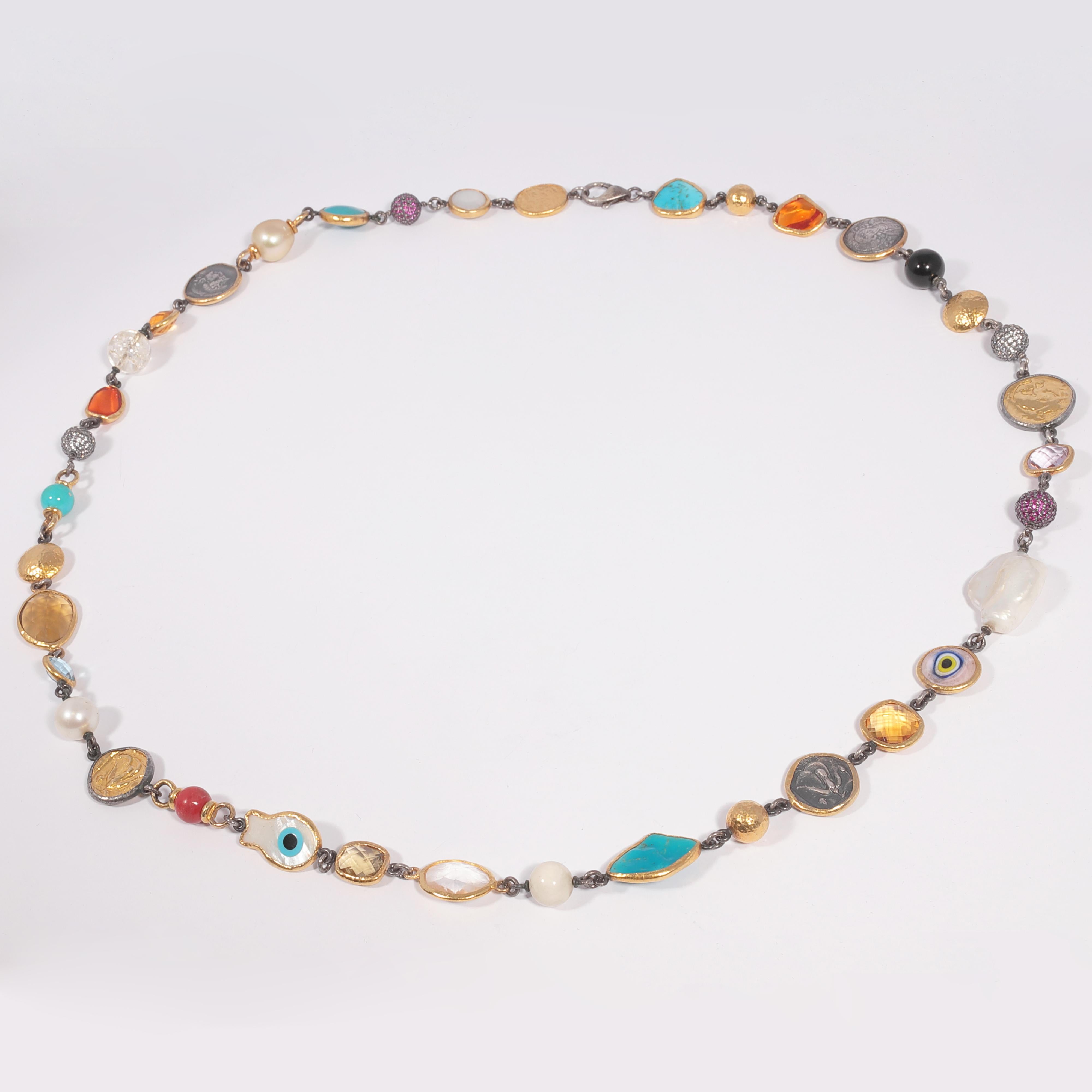 This unique necklace, set in 23.6 karat gold and sterling silver, features a striking collection of coins, turquoise, mother-of-pearl, citrine, topaz, onyx, quartz, fire opal, pink sapphires, white sapphires, and cultured pearls.  The necklace is