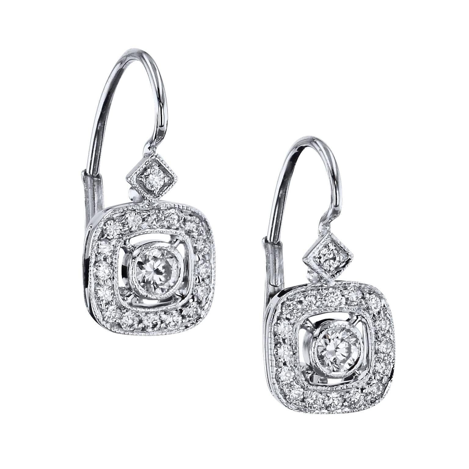 These swank handmade earrings epitomize elegance and are essential for the woman who likes a little glamour. Two diamonds with a total weight of 0.38 carat (H/I/SI1) are bezel- set with a surrounding diamond pave halo on air line. Fashioned in 18
