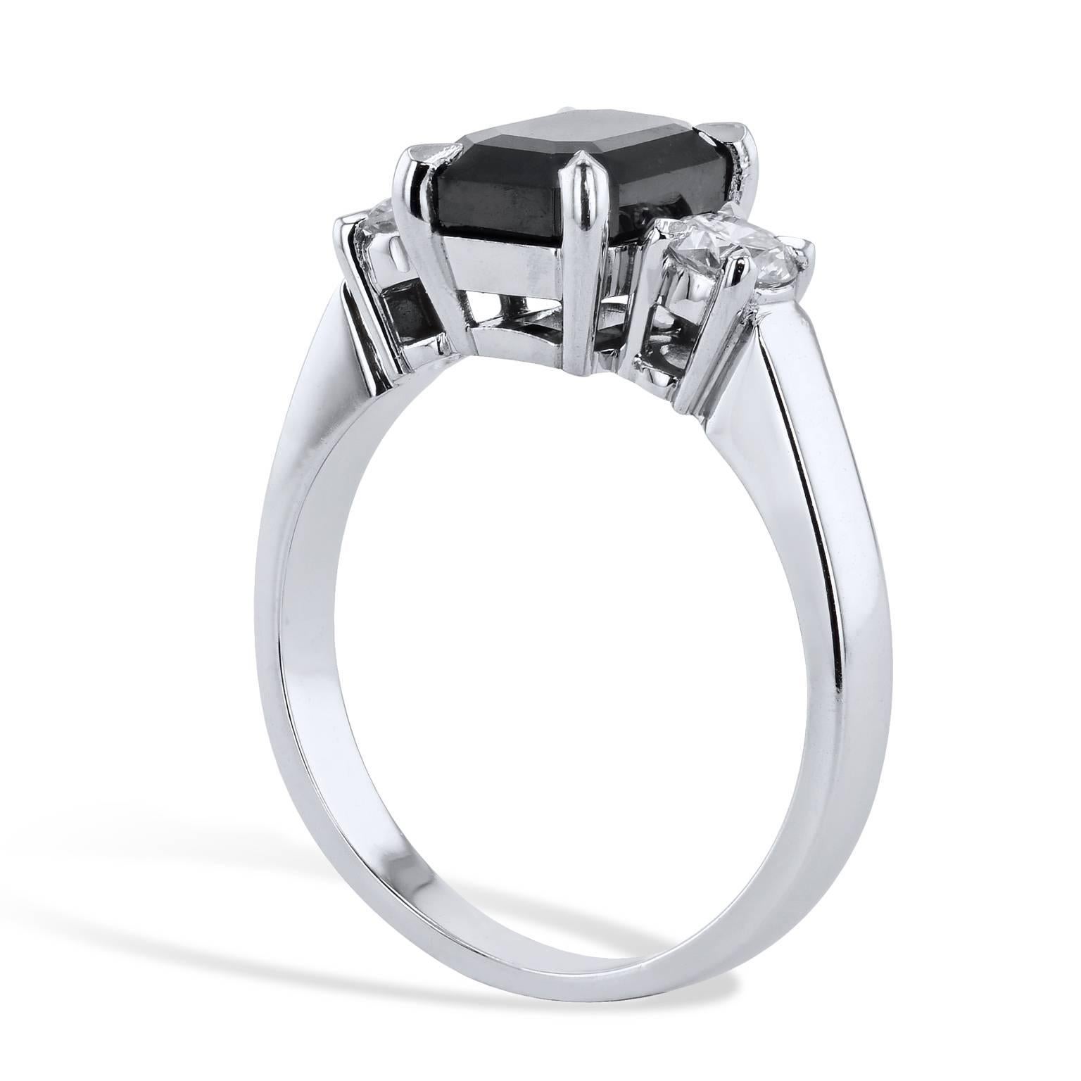 This handmade black and white diamond engagement ring conjures the thought of the night sky punctuated by starlight. A  2.34 carat emerald cut black diamond is four-prong set at center and feature 0.40 carat of accent diamonds (H/I/I1) on both sides