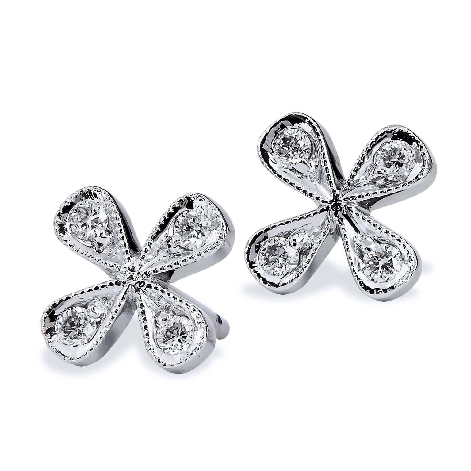 This sweet and simple H & H original design features 14 karat white gold fashioned in the shape of a four petal flower. Eight diamonds, with a total weight of 0.15 carat (H/SI2/I1), are pave set with milgrain work along the perimeter. Exude a fun