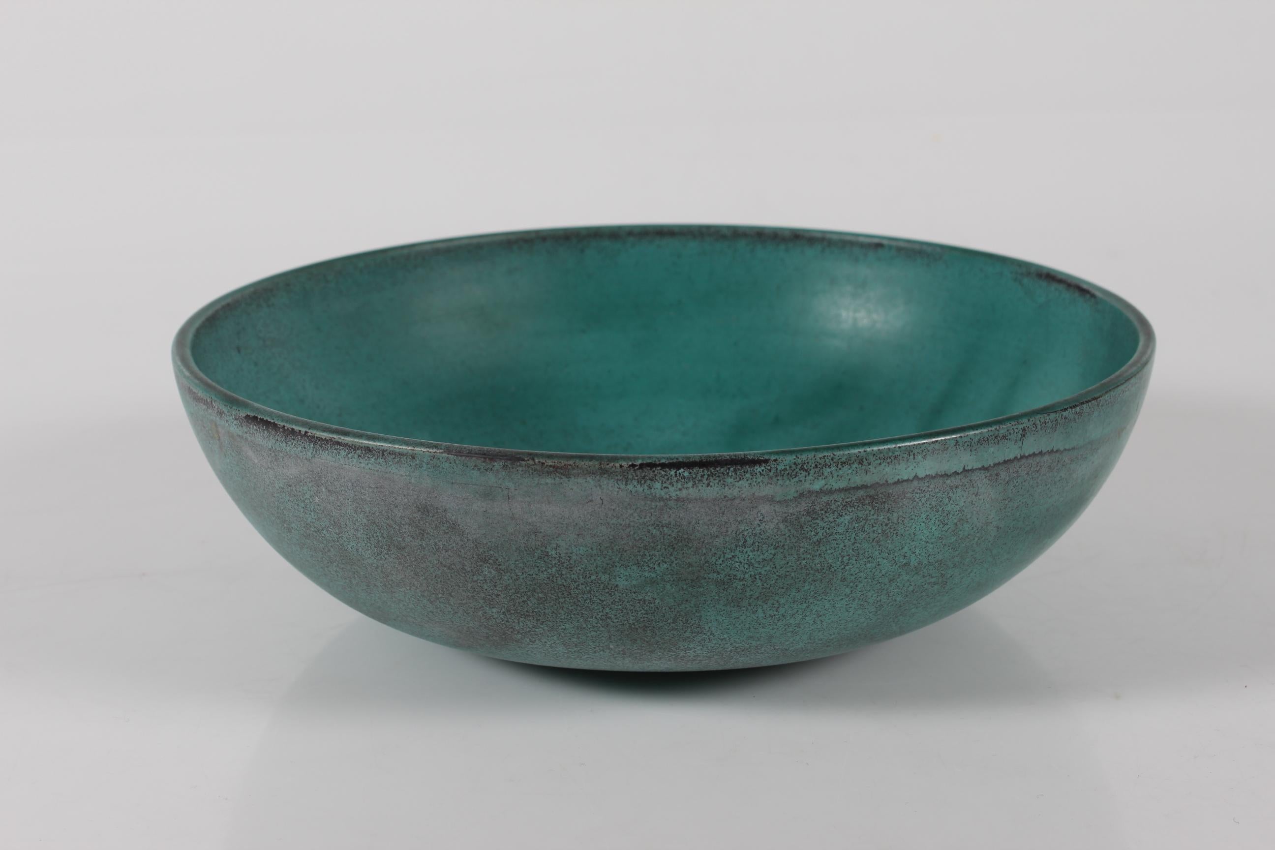 Round Art Deco ceramic bowl made by Nils Kähler in the 1940s for the pottery workshop Kähler in Næstved, Denmark.

The bowl is decorated with smooth  verdigris green glaze with a touch of black.

Marked: HAK 

Very good condition without repairs or