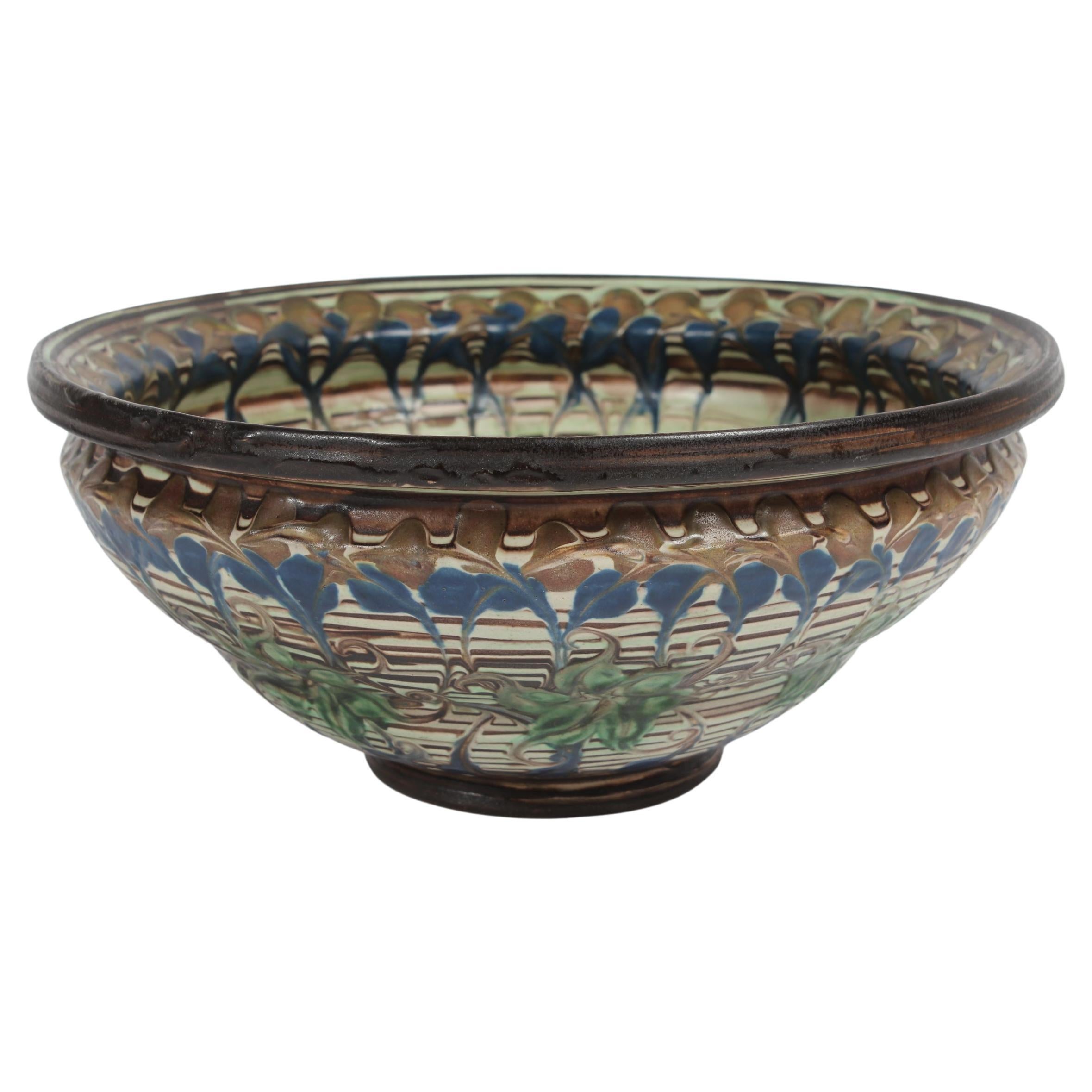 Grand bol en céramique à motif floral fabriqué dans l'atelier de poterie H. A. Kähler à Næstved, Danemark, vers 1930. 

Il est décoré par Jens Thirslund (1892-1942) selon une technique spéciale. 
La glaçure est appliquée dans les directions
