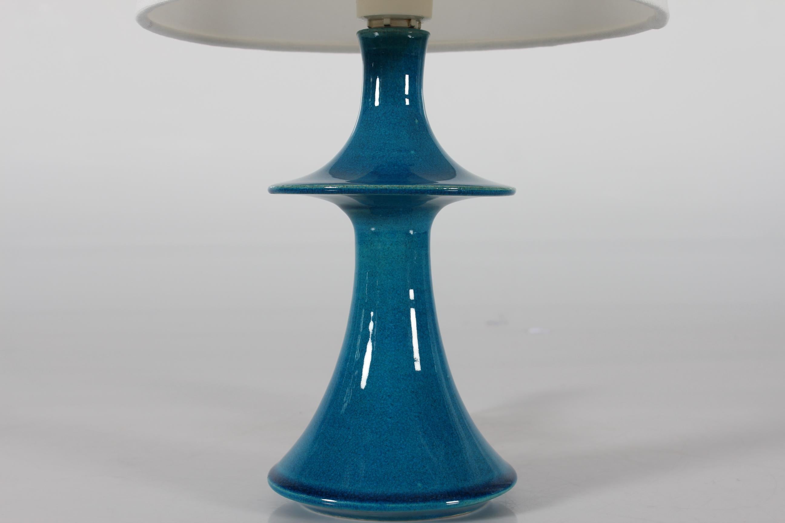 Danish table lamp with UFO shaped sculptural design by Poul Erik Eliasen made at the danish ceramic workshop H. A. Kähler (HAK).
The lamp is created in the 1970s of stoneware decorated with glossy turquoise blue glaze.

Hand signed 