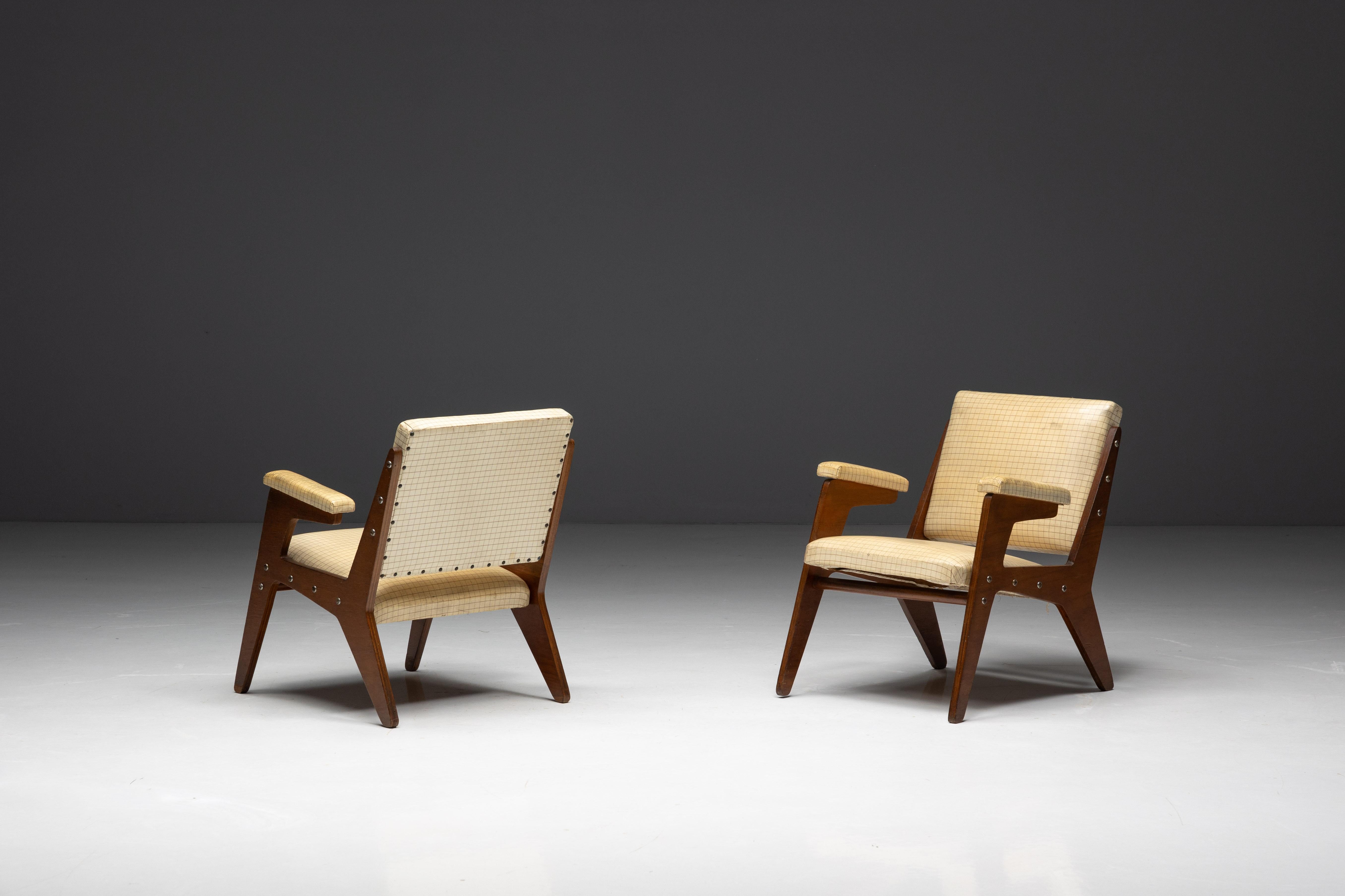 This set of two lightweight armchairs by José Zanine Caldas exemplifies his mastery of form and material. Constructed with two precision-cut plywood pieces screwed to the seat and back, the chairs feature wooden frames covered with no-sag springs