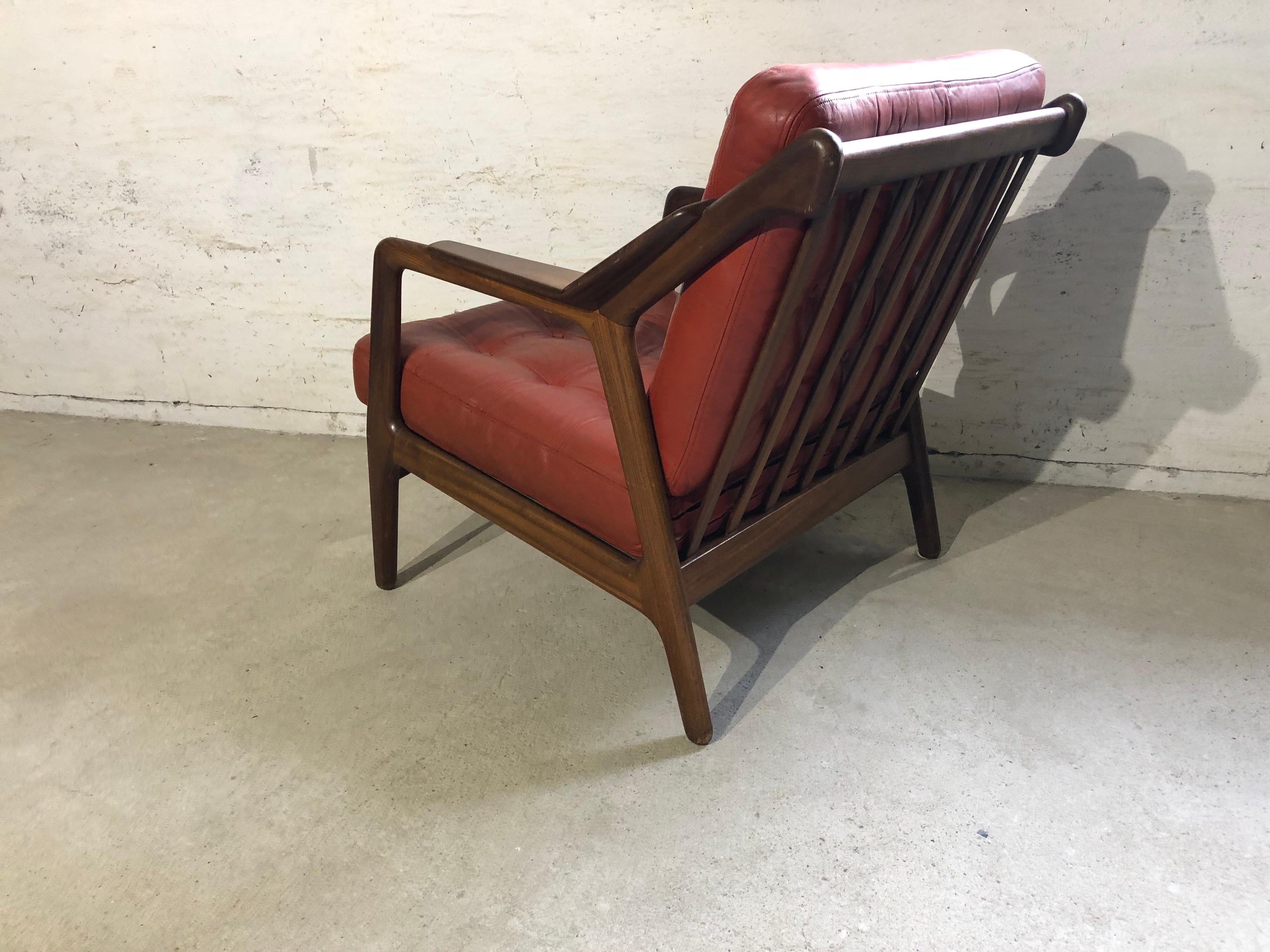 H. Brockmann Petersen Loungechair, with red leather upholstery, wooden frame is made in teak. A stunning Mid-Century Modern piece. 
The chair is in a good condition.