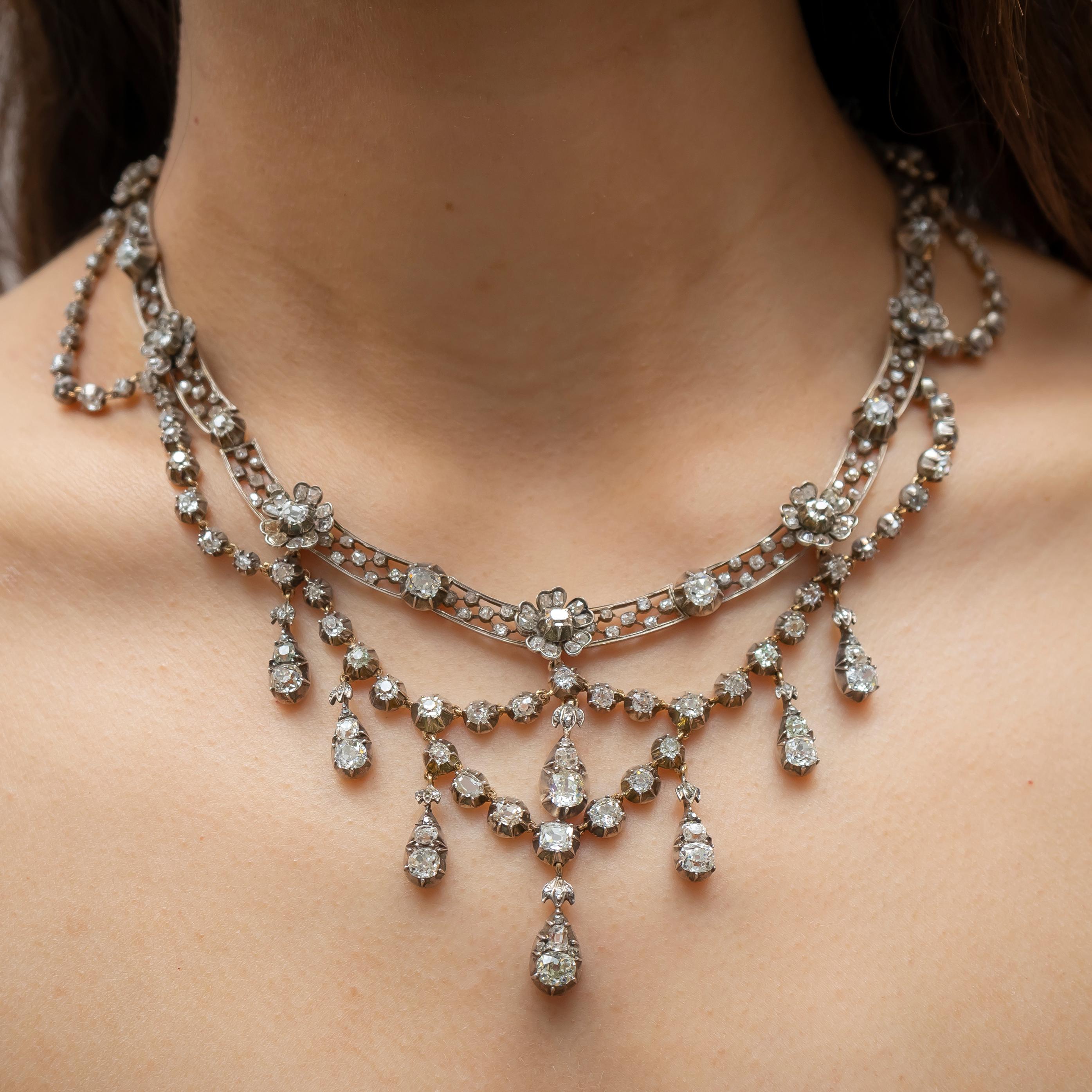 A German, Belle Époque, diamond fringed, openwork necklace, with alternating floral clusters and single, old mine-cut diamonds, with a removable diamond fringed swag, connected by a hook at each floral cluster, comprising eight old cut-diamond