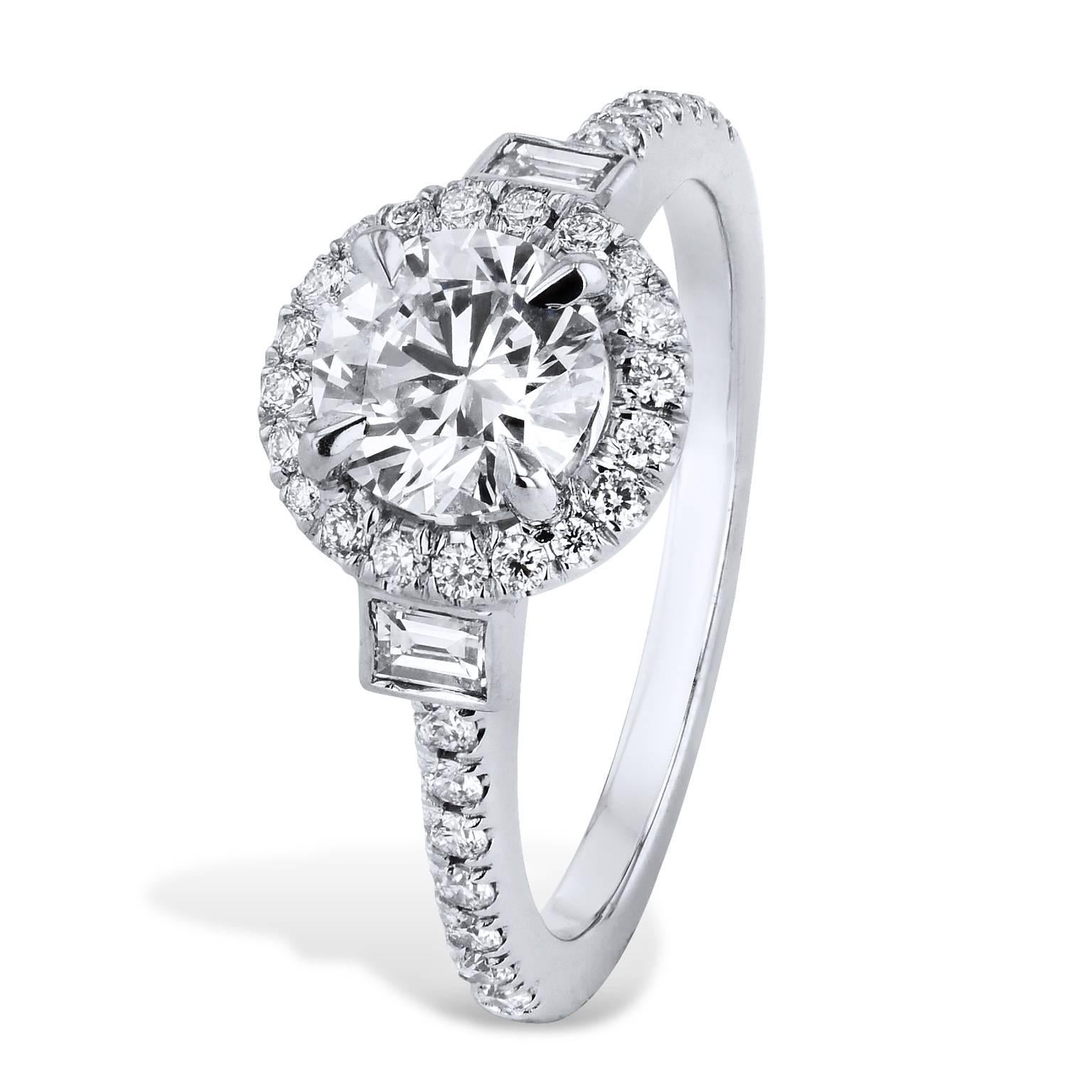 This platinum engagement ring features a 1.00 carat round prong-set diamond (E/VS1) at center. 0.20 carat of round diamonds are pave-set in halo surrounding the center diamond (D/E/VS) as 0.14 carat of pave-set diamond cascade down the shank