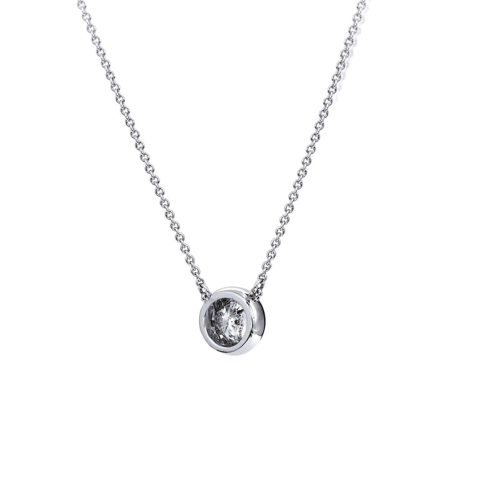 Crafted in 18 karat white gold, this pendant features a 1.04 carat round brilliant cut bezel set diamond graded K/SI1. This necklace is a staple jewelry piece for every woman's wardrobe. It can be dressed up for a special occasion, layered with