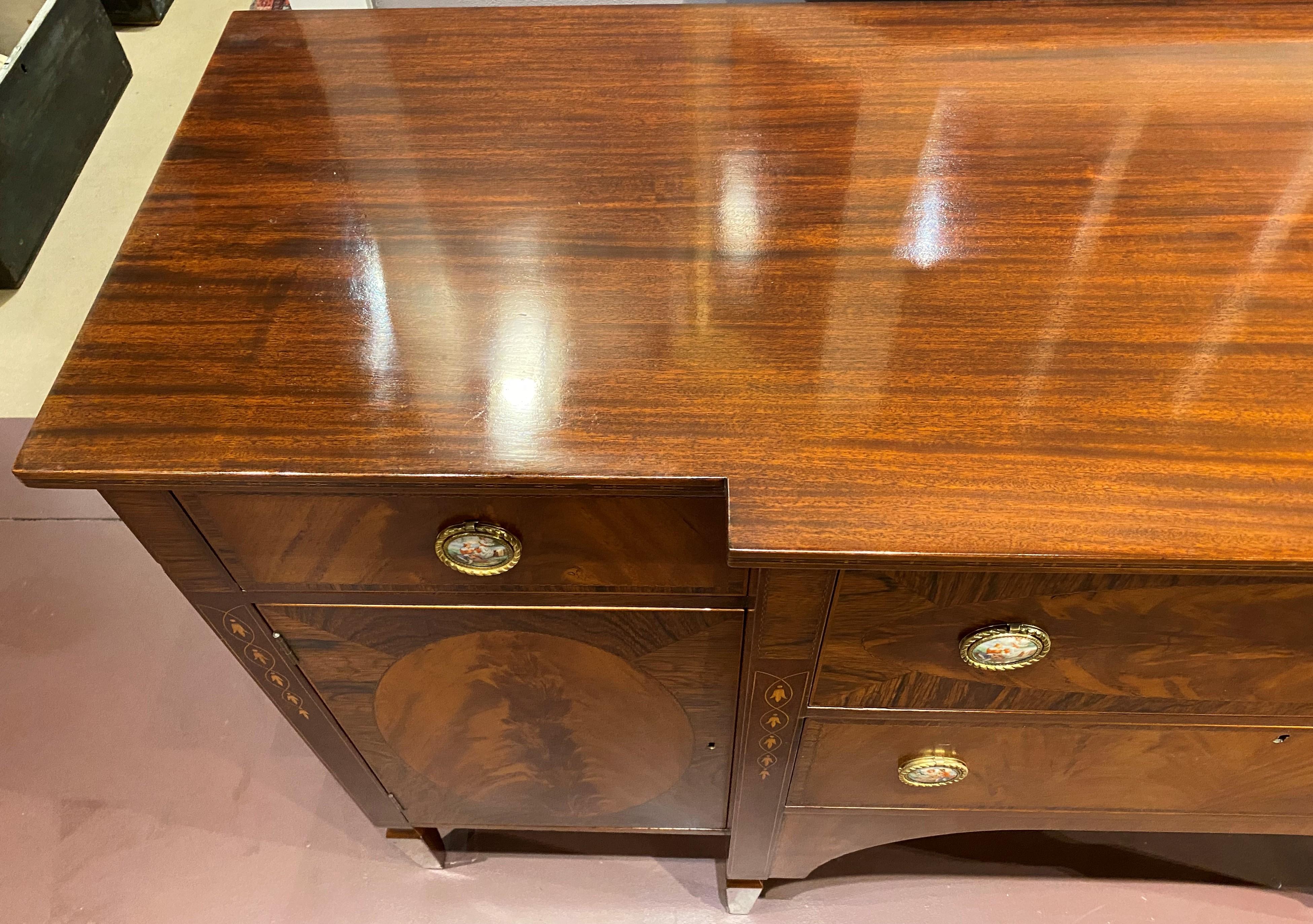 A beautiful mahogany sideboard By H. Sacks & Sons (Brookline, MA) with conforming top surmounting two central drawers, the top drawer with a drop front which opens to two silver drawers, flanked by two fitted drawers over two single door storage