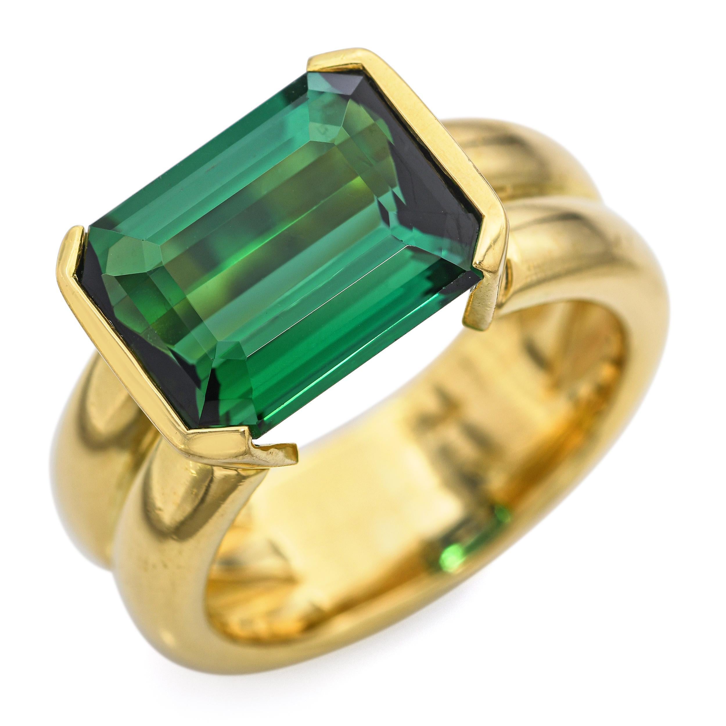 Cette bague remarquable met en valeur une tourmaline vert vif taillée en émeraude, sertie horizontalement dans un anneau d'or élégant et poli. La pierre substantielle est solidement maintenue par quatre griffes d'angle, soulignant sa précision